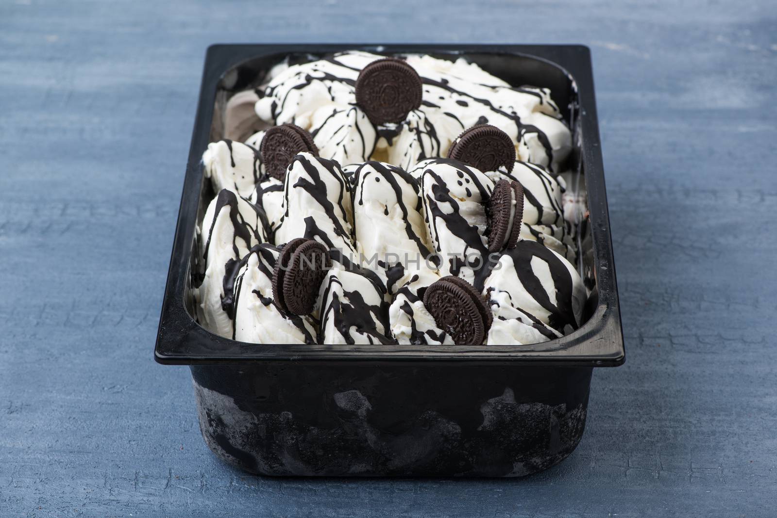 appetizing ice cream in a plastic container on a decorative blue background