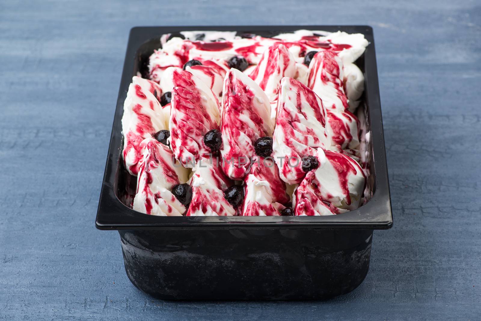 appetizing ice cream in a plastic container on a decorative blue background