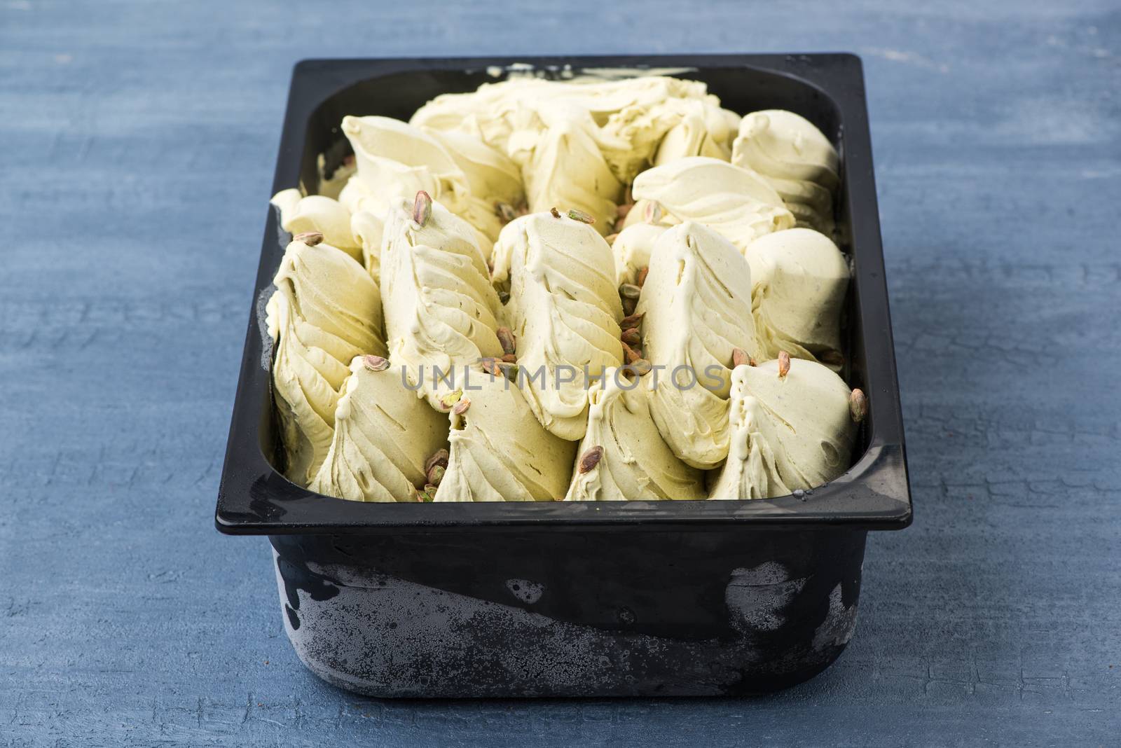 appetizing ice cream in a plastic container on a decorative blue background