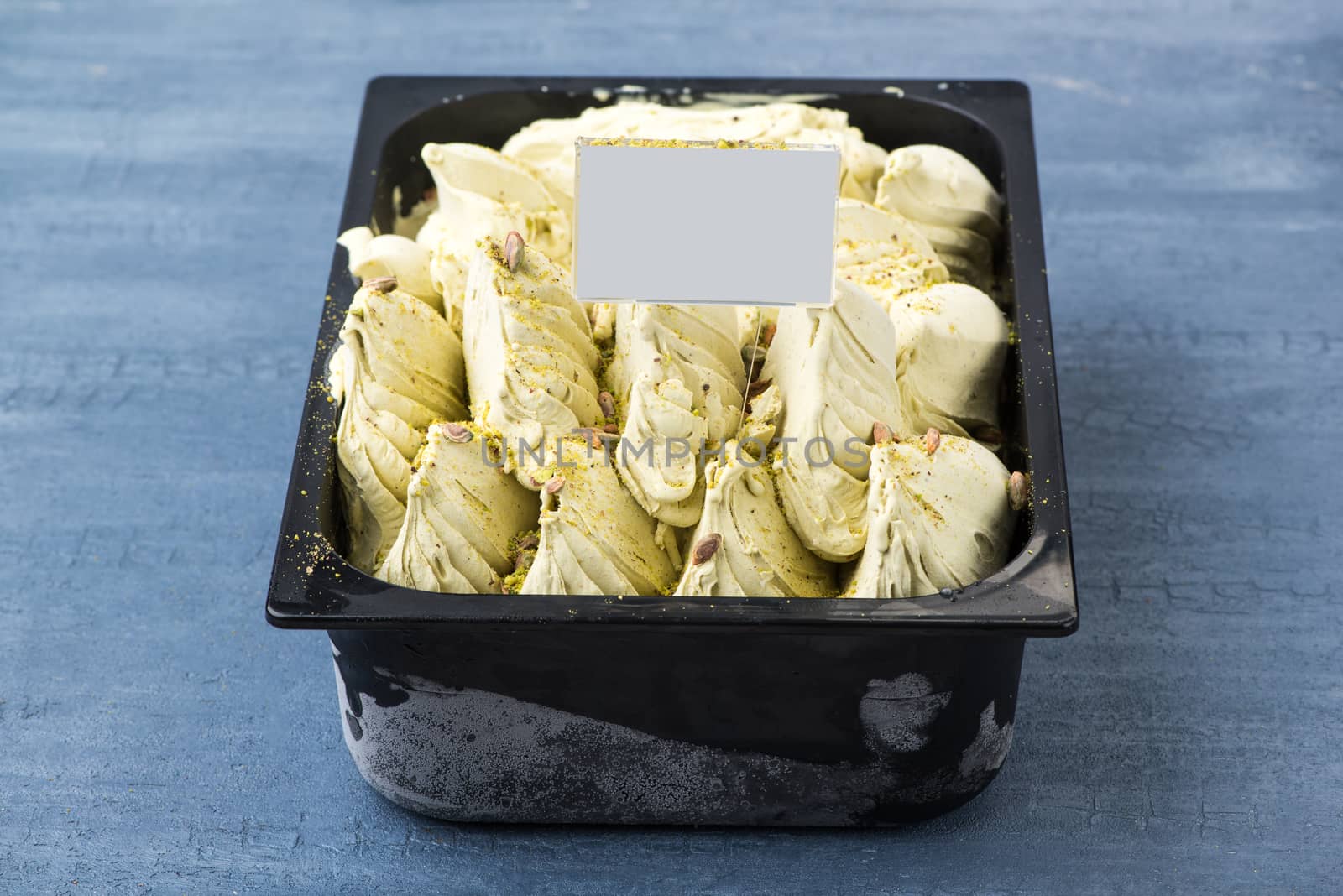 appetizing ice cream in a plastic container with a price tag on a decorative blue background