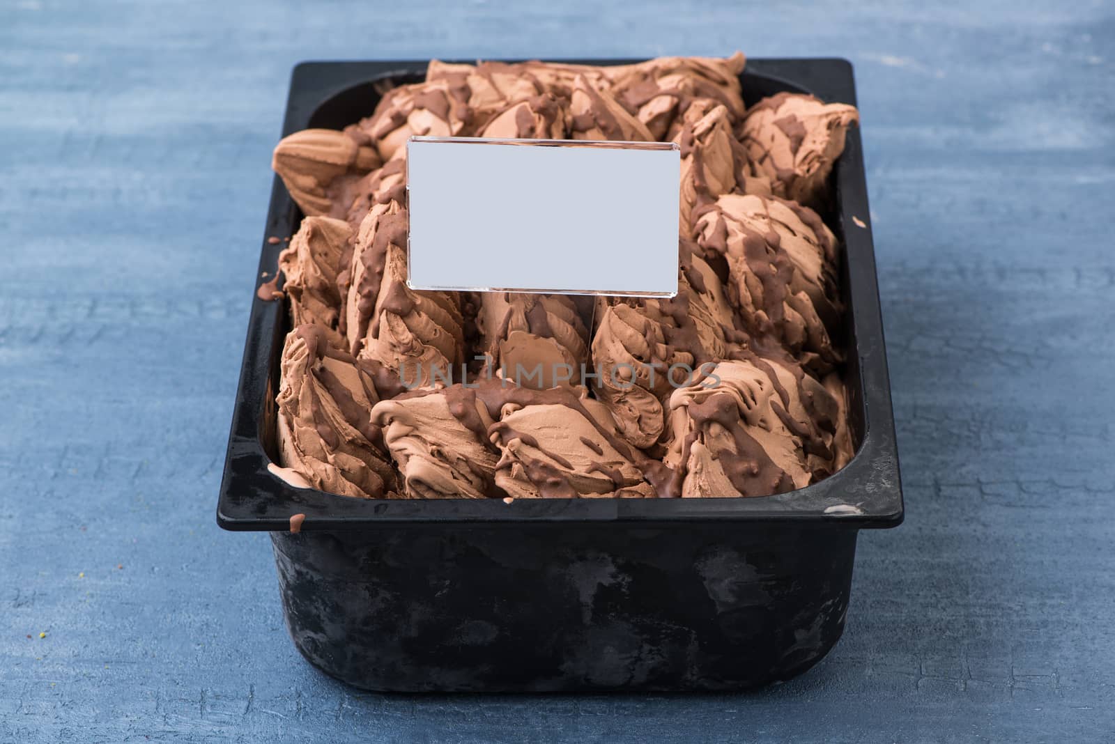 appetizing ice cream in a plastic container with a price tag on a decorative blue background
