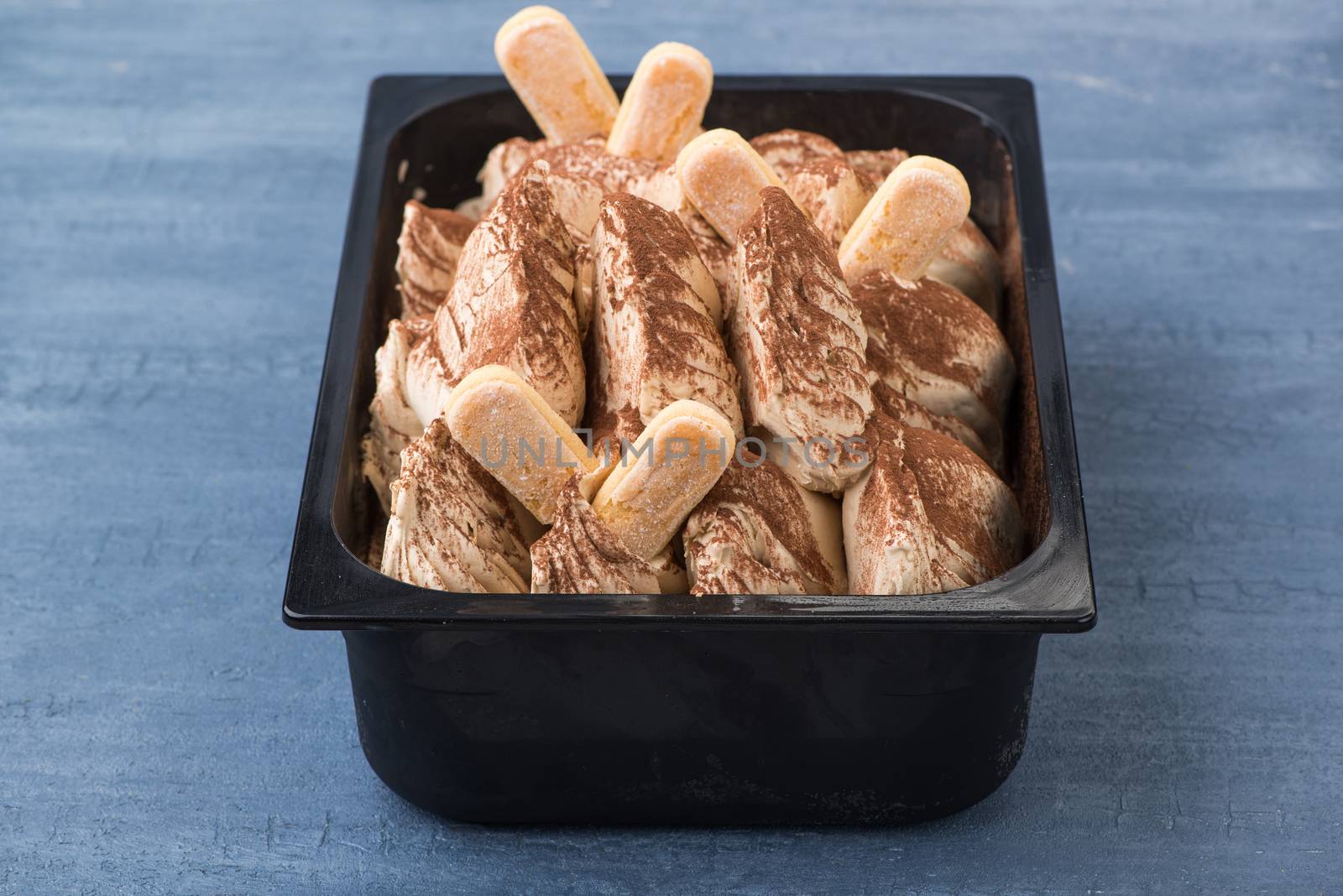 appetizing ice cream in a plastic container on a decorative blue background