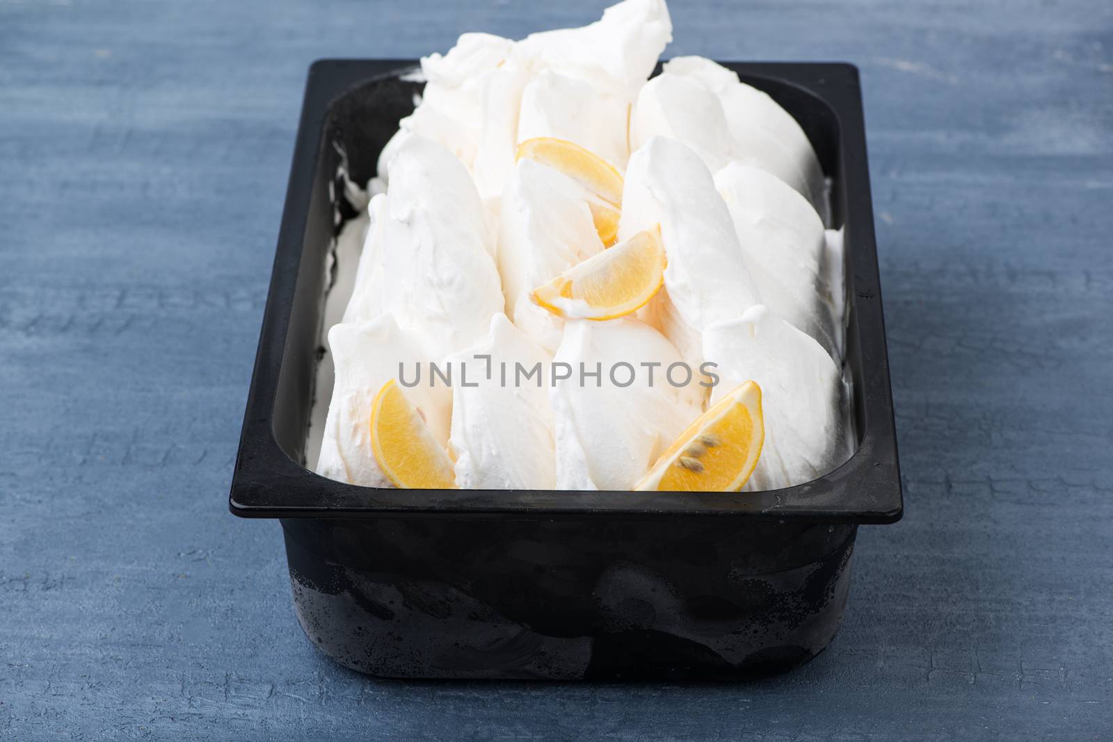 appetizing ice cream in a plastic container on a decorative blue background