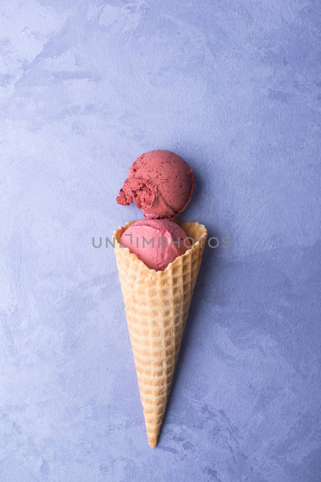 ice cream in a waffle horn on an ornamental purple background, top view