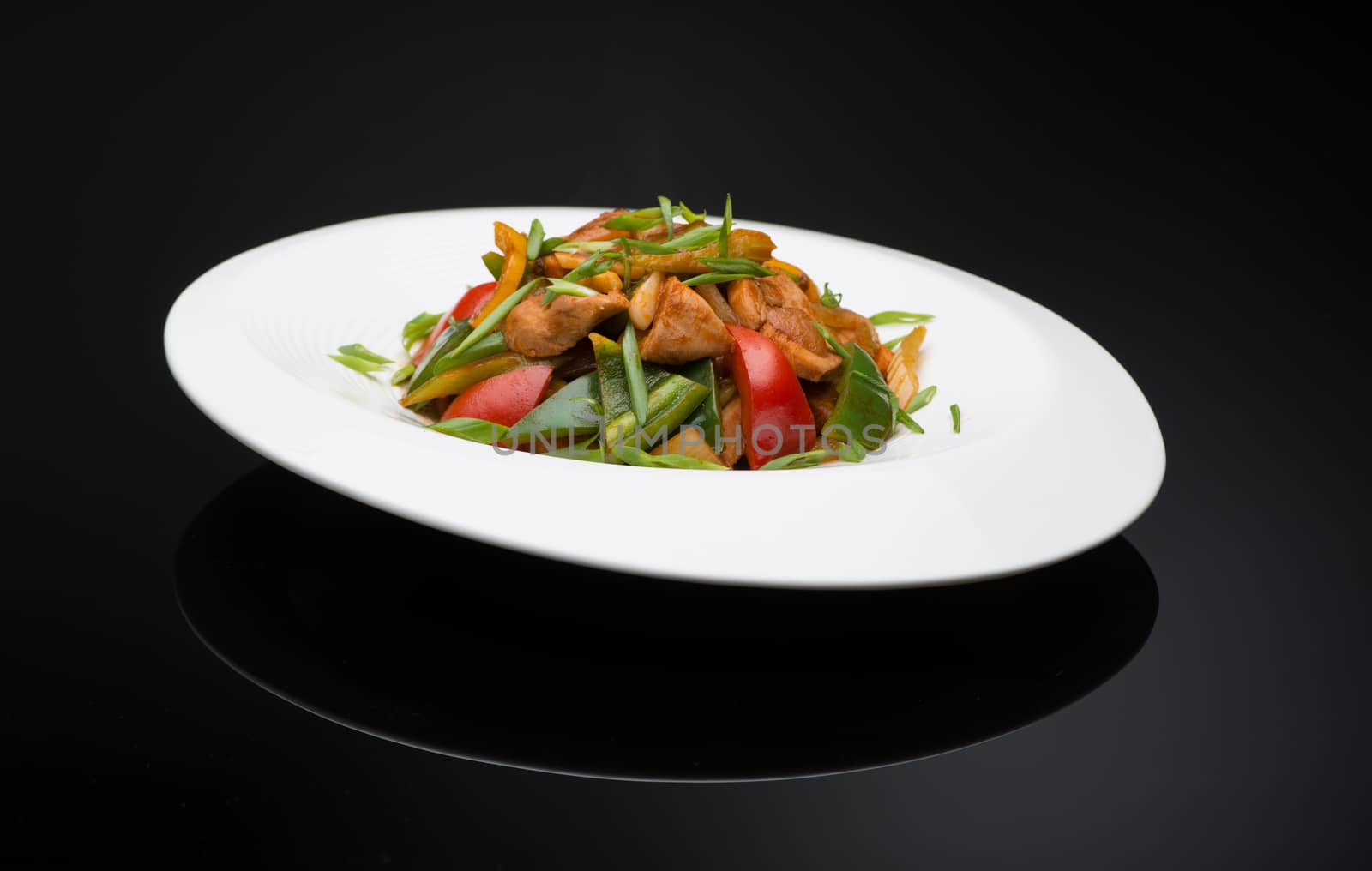 meat salad with bell pepper on a black background, isolated