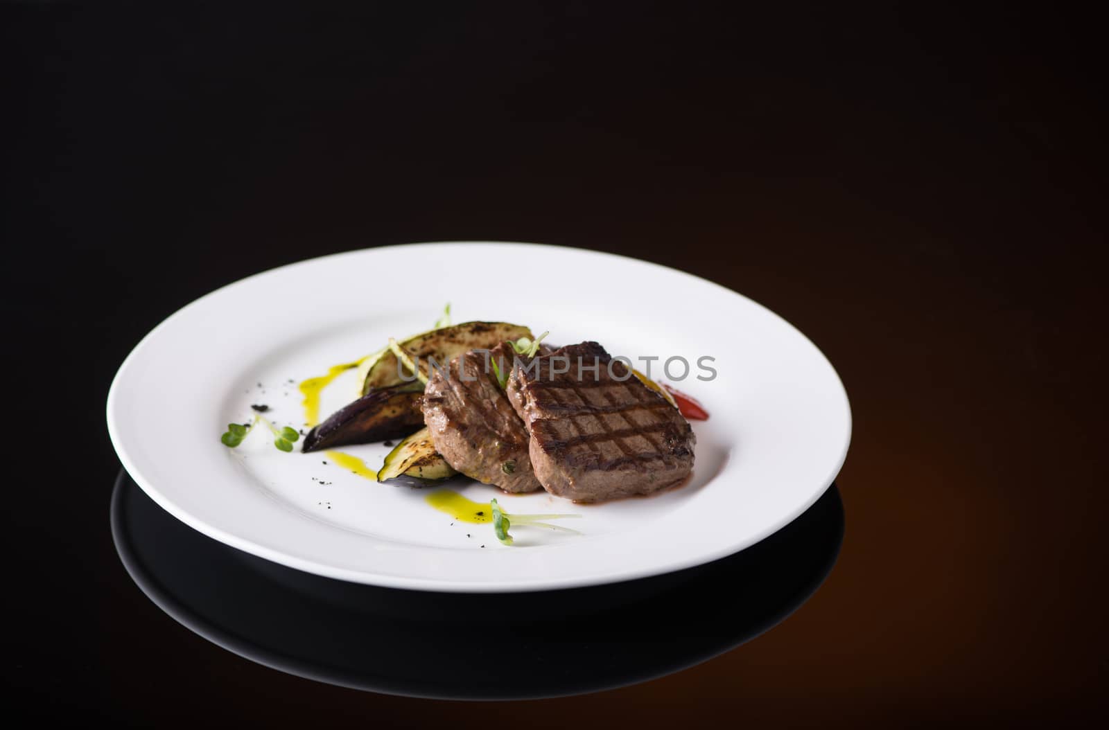 dish of fried meat in a plate on a black background