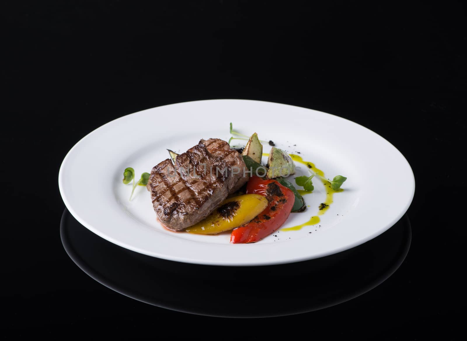 dish of fried meat in a plate on a black background