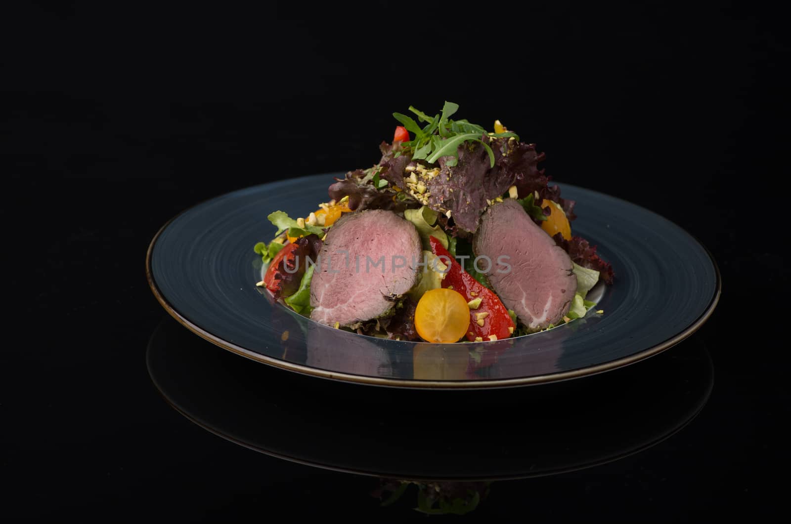salad of meat and vegetables on a black background, isolated