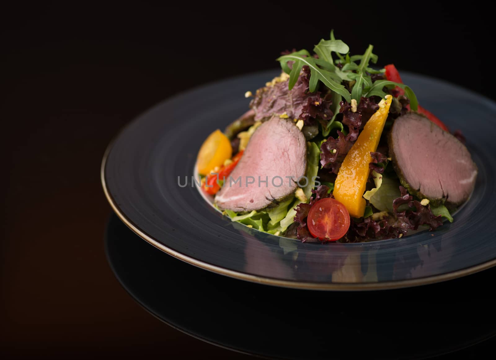 salad of meat and vegetables on a black background, isolated