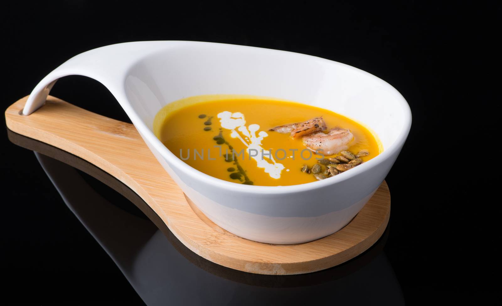 shrimp soup in a white cup on a black background, isolated