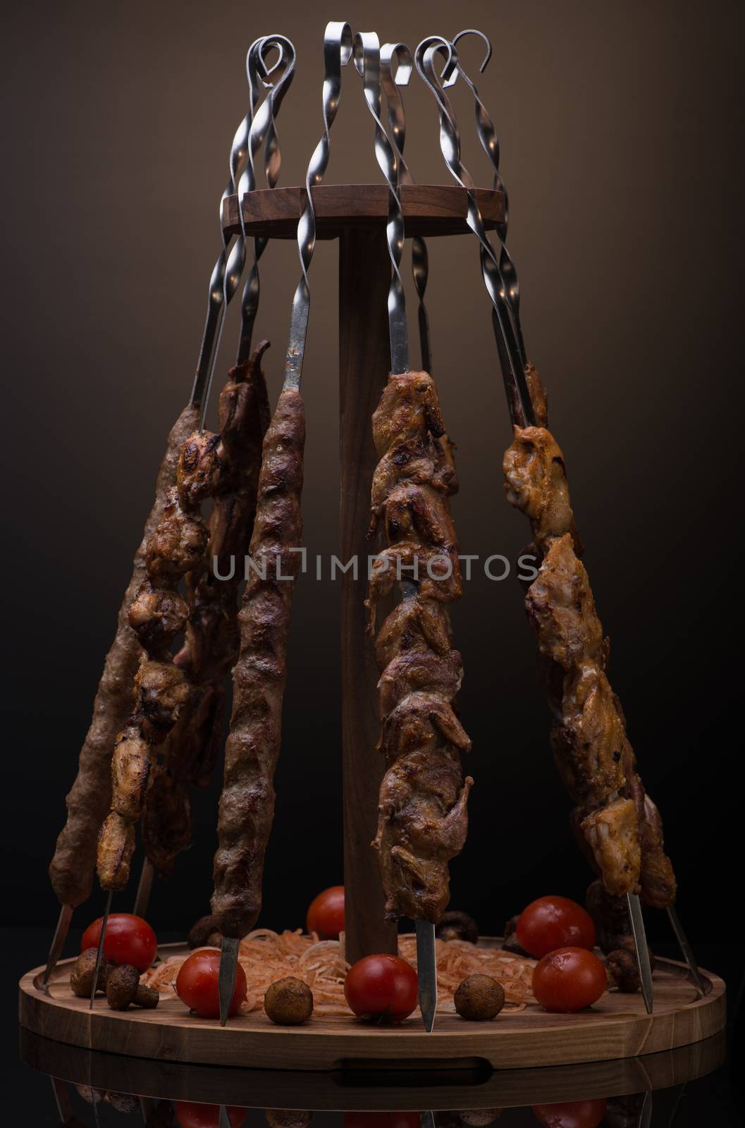 kebab on skewers in a vertical position on a dark background