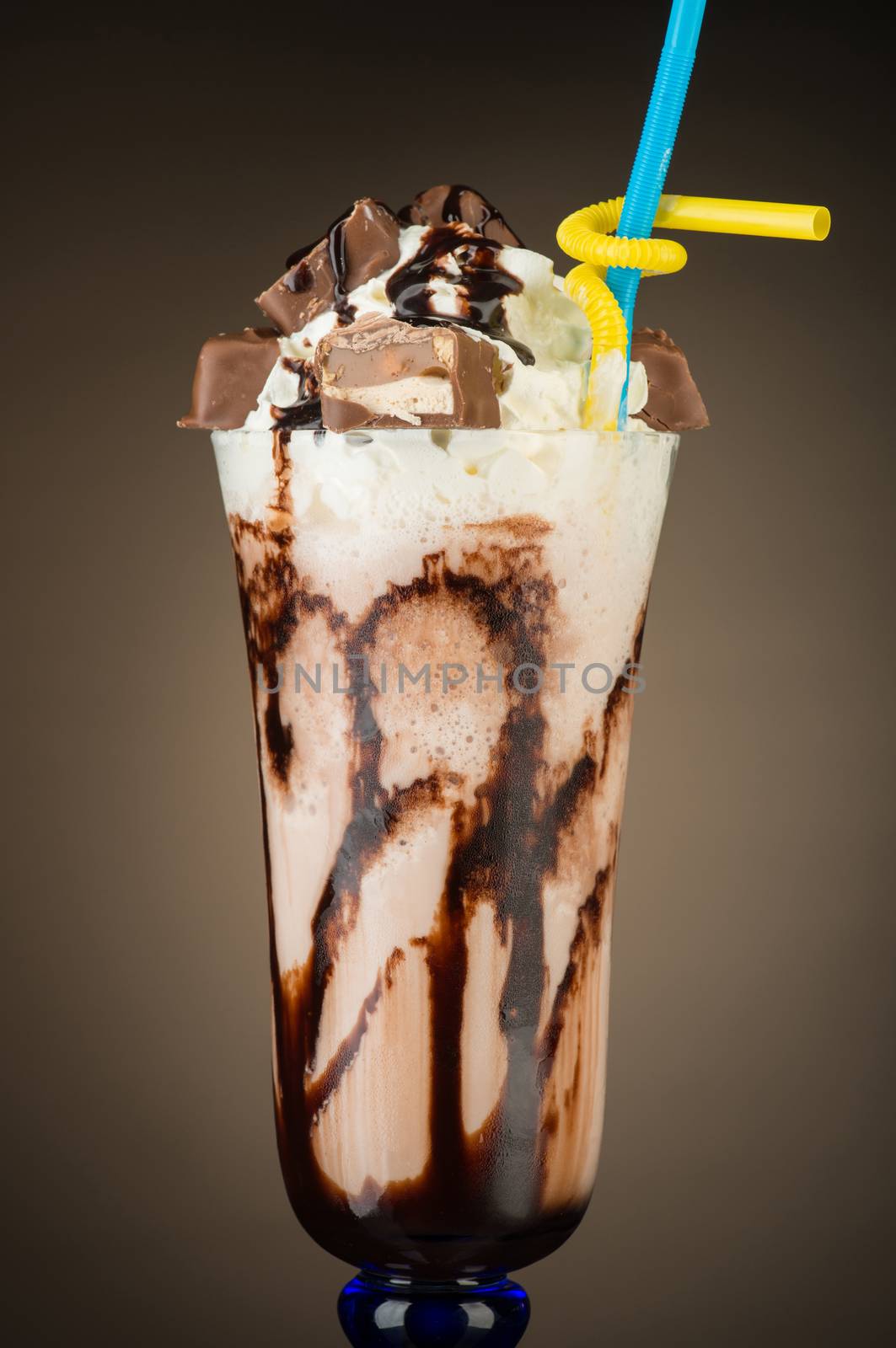 chocolate fruit cocktail ice cream with straw on brown backlit background, isolated. summer tropical smoothie