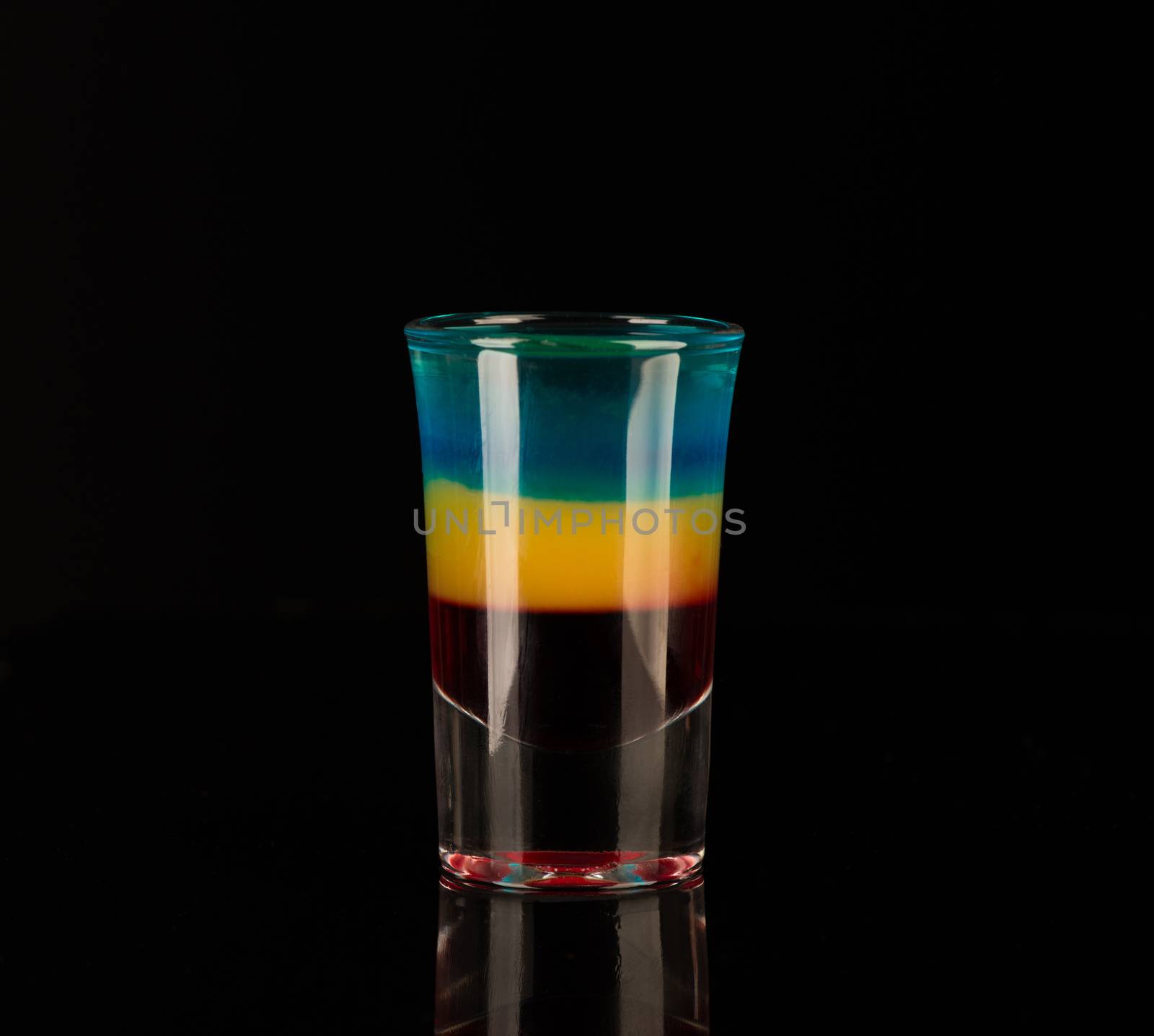 mixed alcoholic liquor in a shot glass isolated on a black background