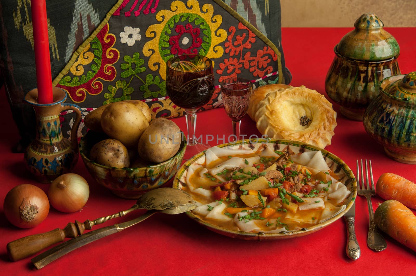 oriental dish of dough and vegetables on a red tablecloth. a still-life from an oriental dish of dough and vegetables on a red tablecloth
