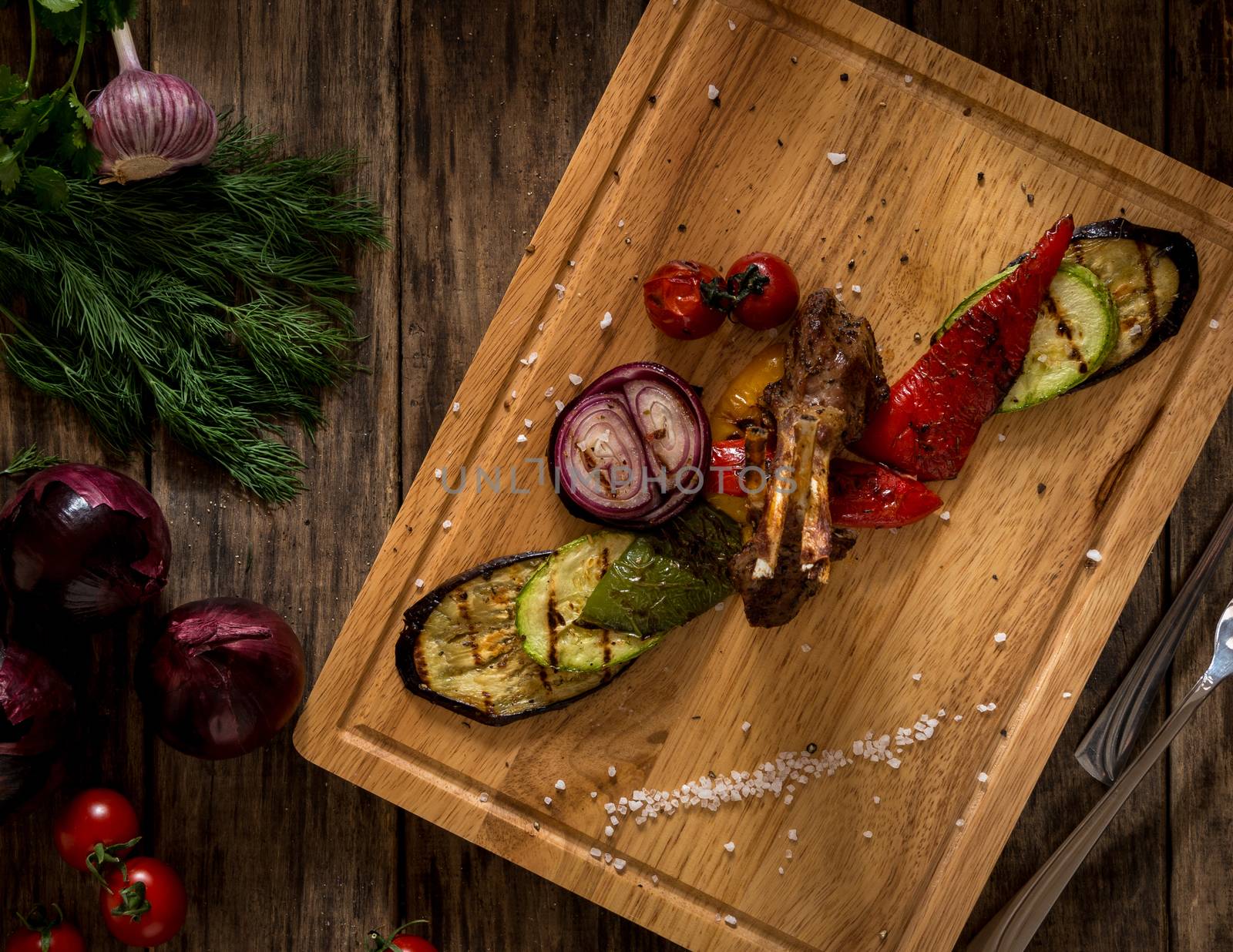 pieces of fried meat and vegetables on a cutting board, top view