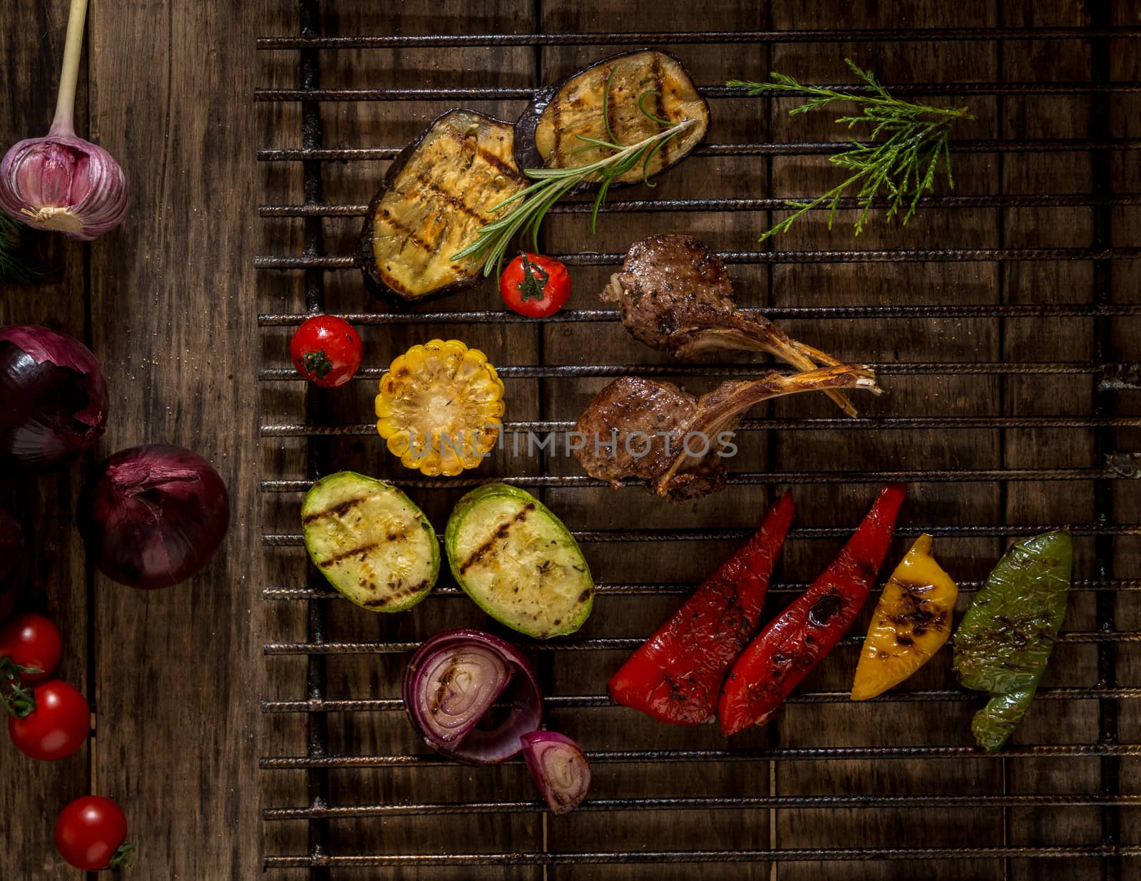 grilled meat and vegetables on a metal lattice, top view. wooden background