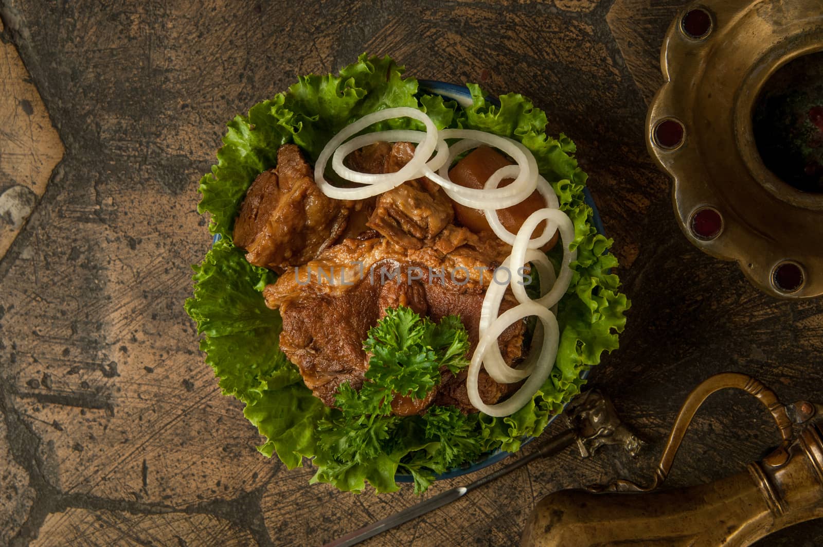 oriental dishes on decorative old tiles. fried meat and jug on decorative old paving stones