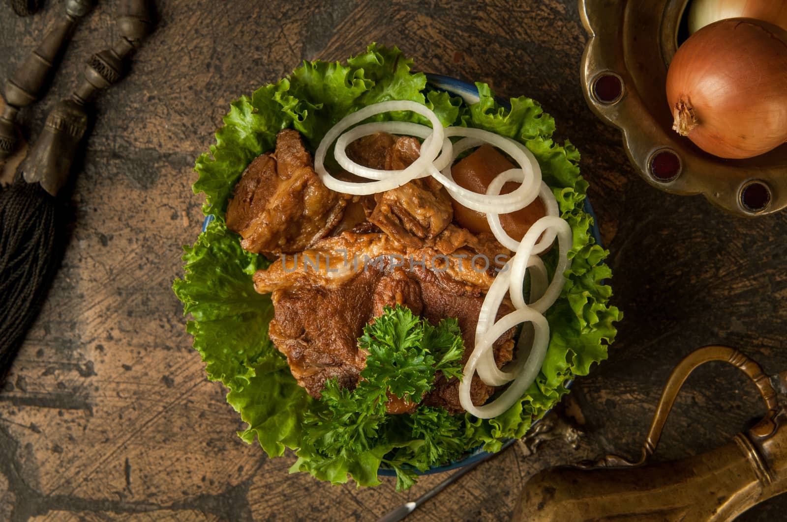 oriental dishes on decorative old tiles. fried meat and jug on decorative old paving stones