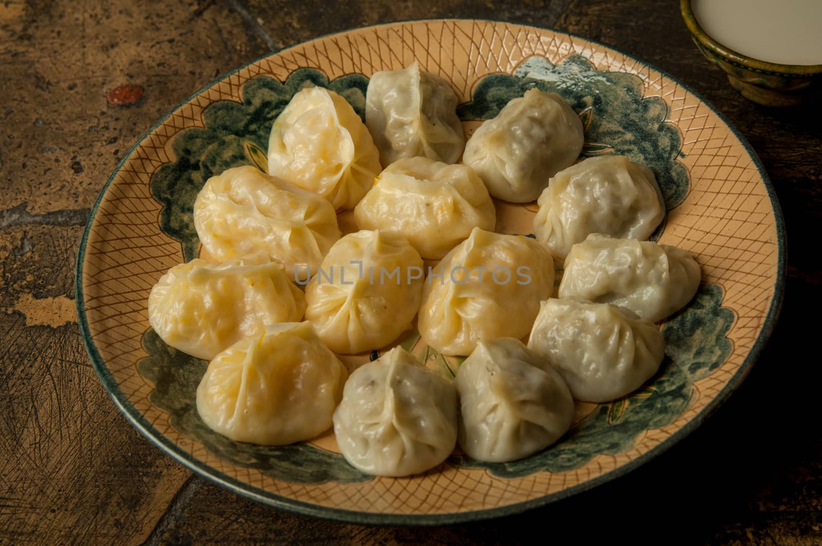 oriental dishes on decorative old tiles. meat in a test on a decorative old paving stone