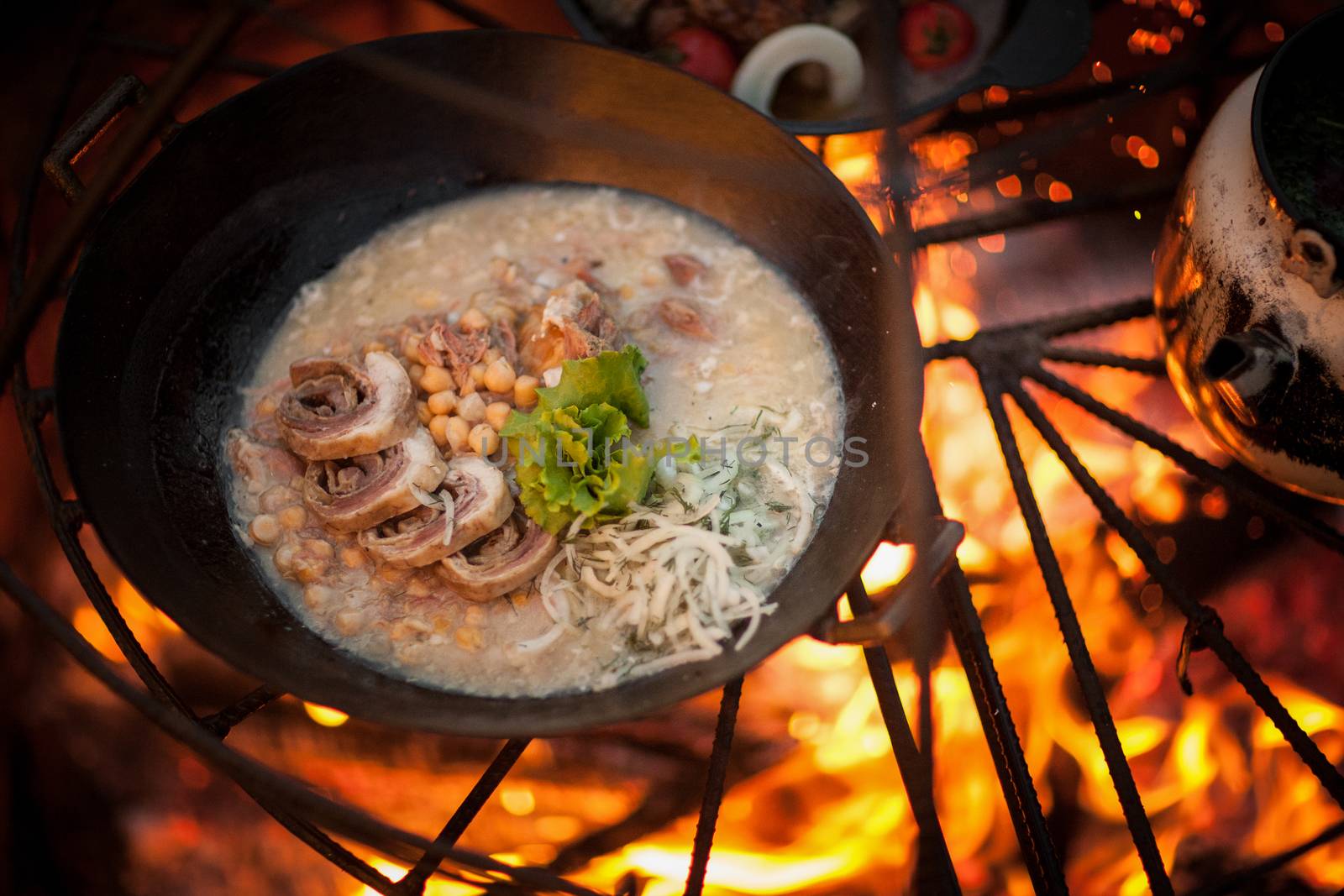 cook a meat dish with peas at the stake with spruce branches