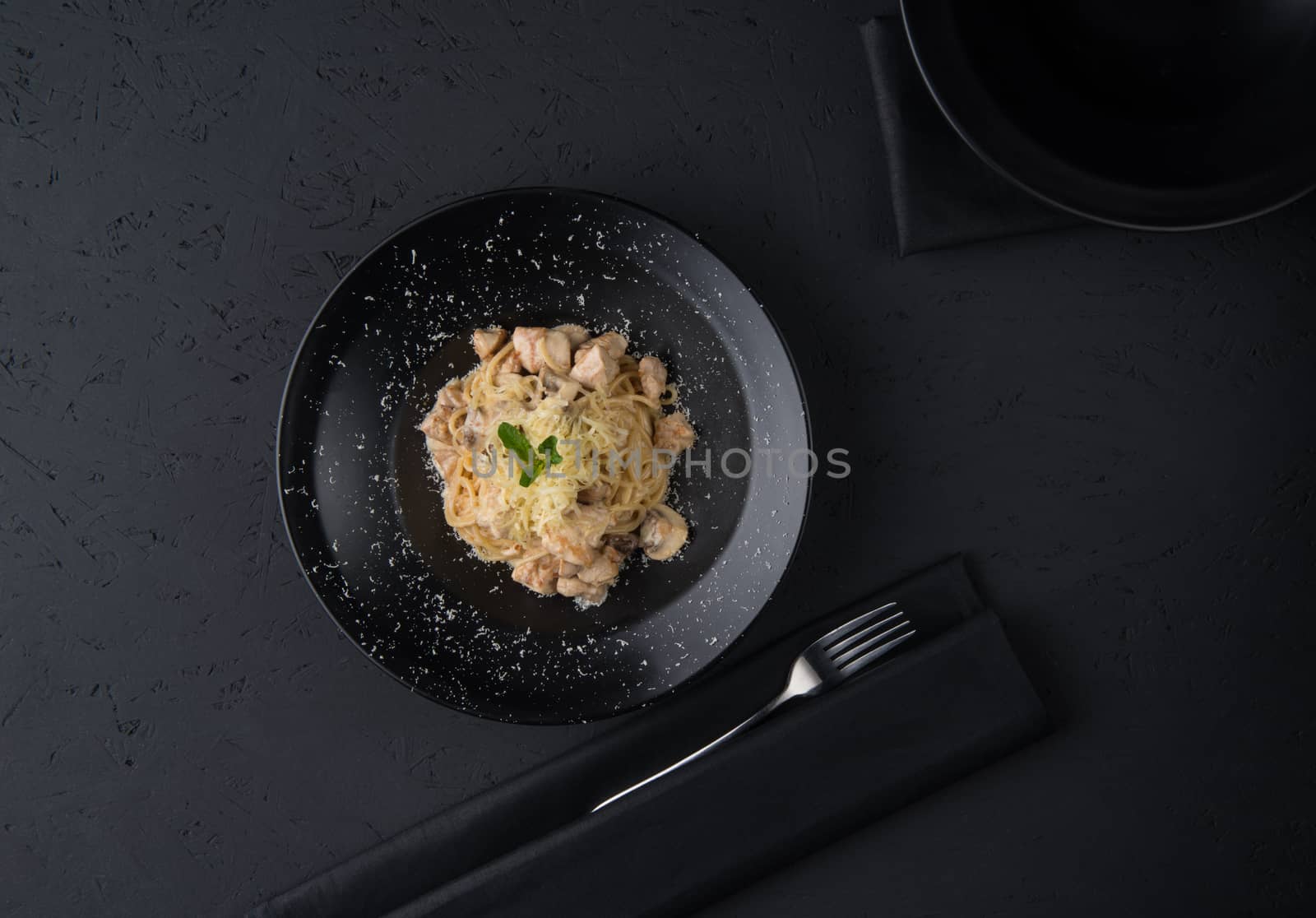 a dish of chicken on the black wooden surface, top view