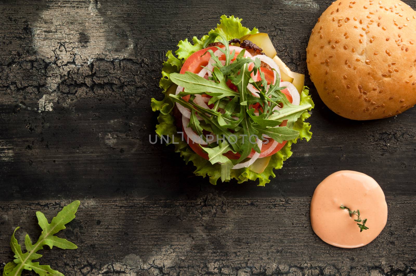 cheeseburger on an old wooden surface of dark color. hamburger with sauce and ketchup on an old wooden surface of dark color