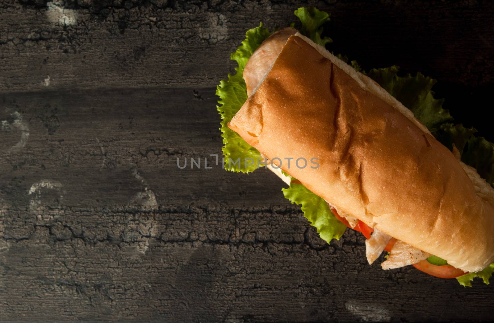 cheeseburger on an old wooden surface of dark color. hamburger with chicken meat on an old wooden surface of dark color