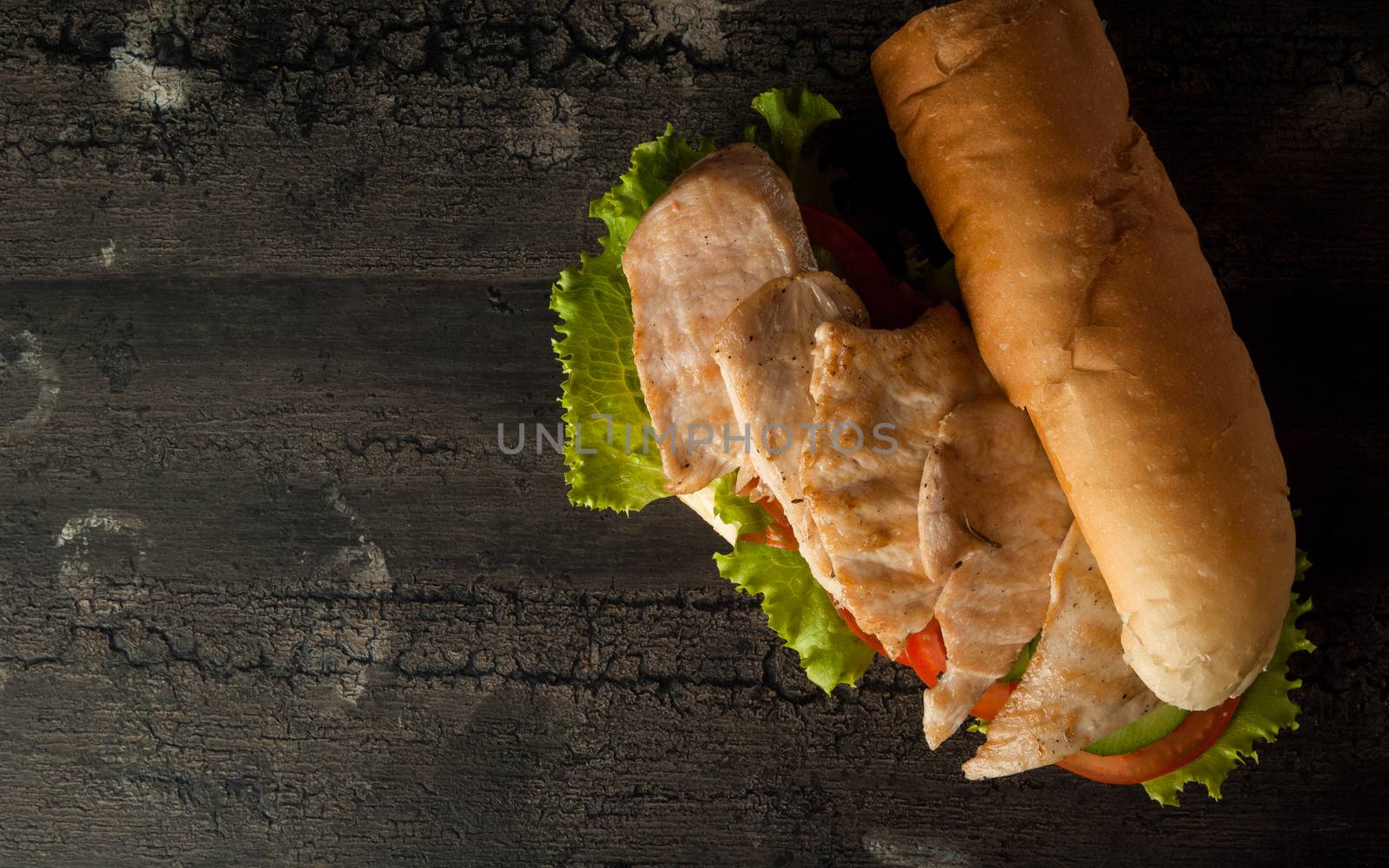 cheeseburger on an old wooden surface of dark color. hamburger with chicken meat on an old wooden surface of dark color