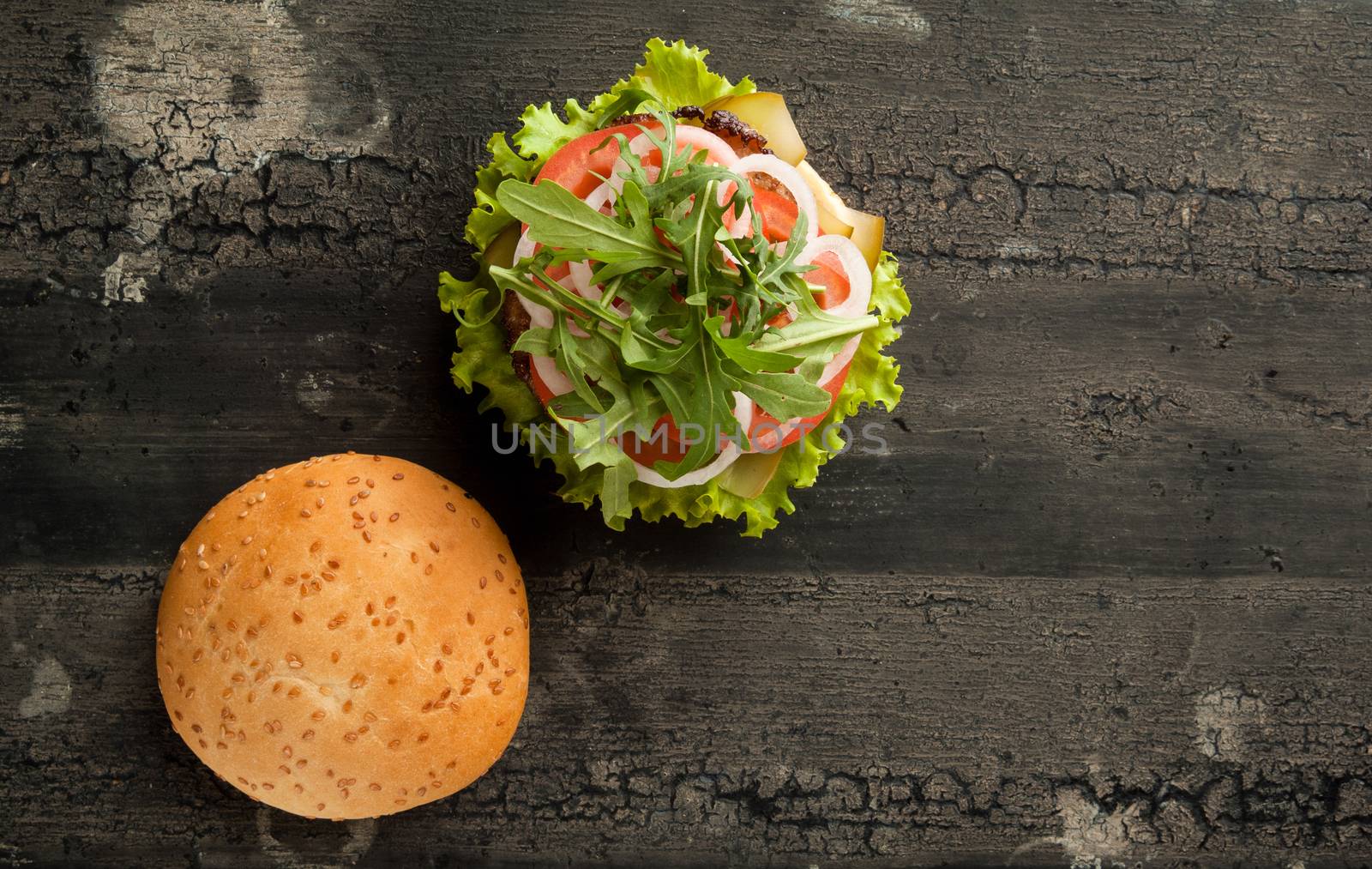 cheeseburger on an old wooden surface of dark color. hamburger with meat and tomato on an old wooden surface of dark color