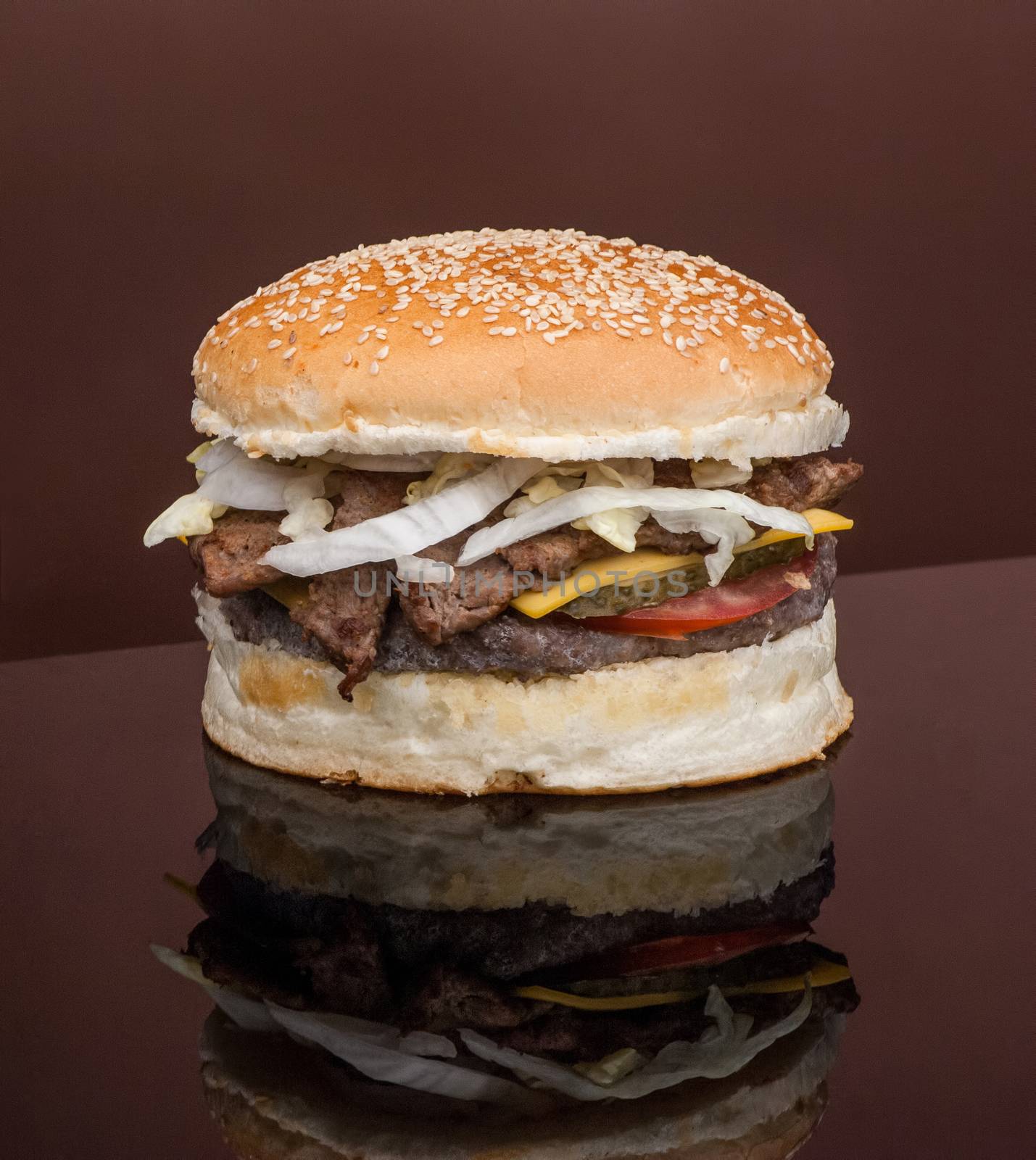 cheeseburger with cutlet and meat on a dark background with reflection closeup