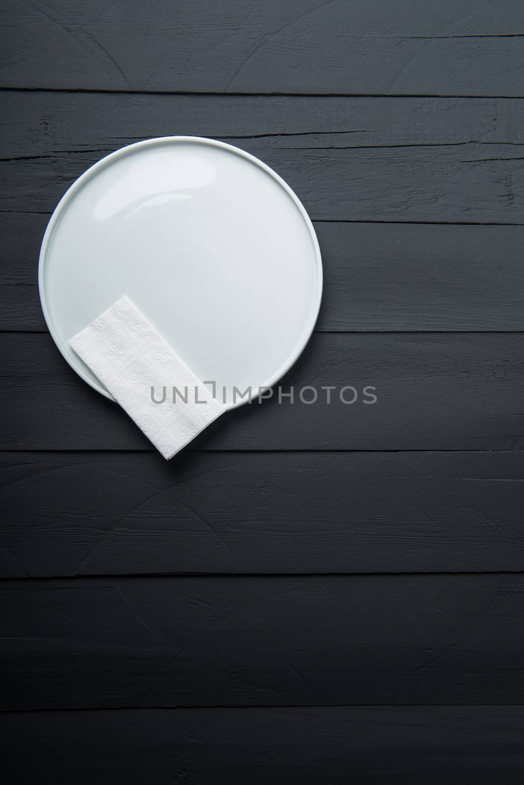 empty white plate on black wooden background
