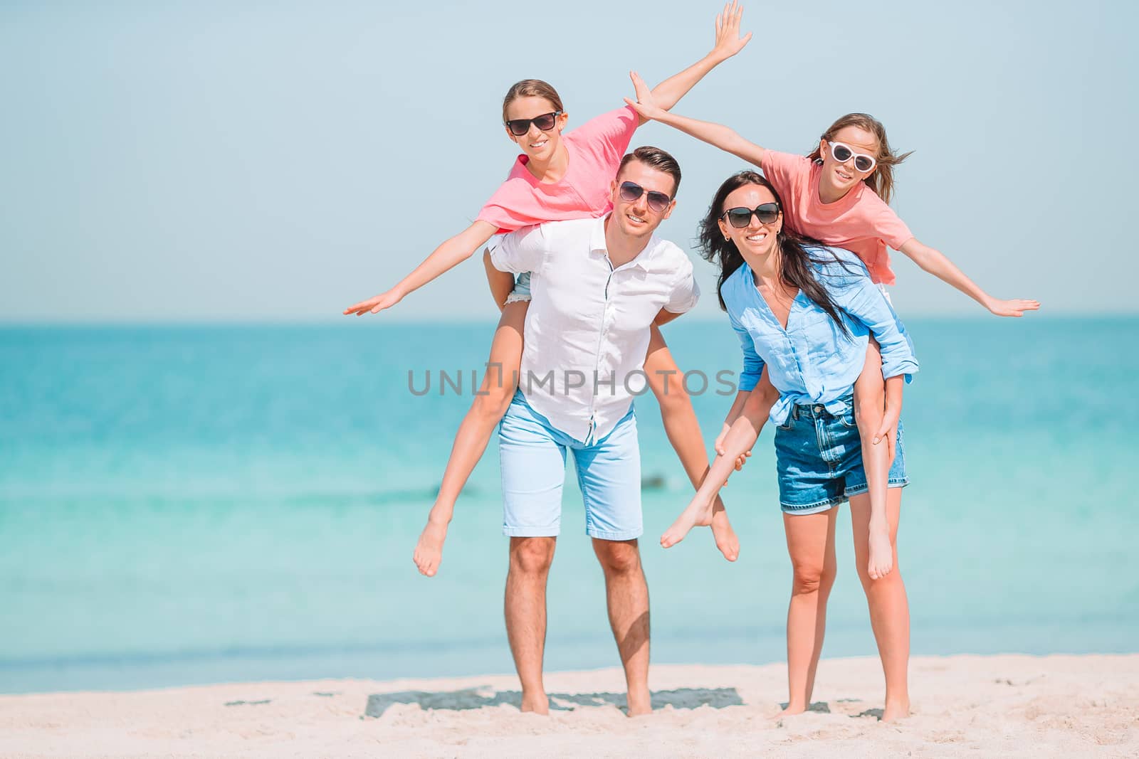 Photo of happy family having fun on the beach. Summer Lifestyle by travnikovstudio
