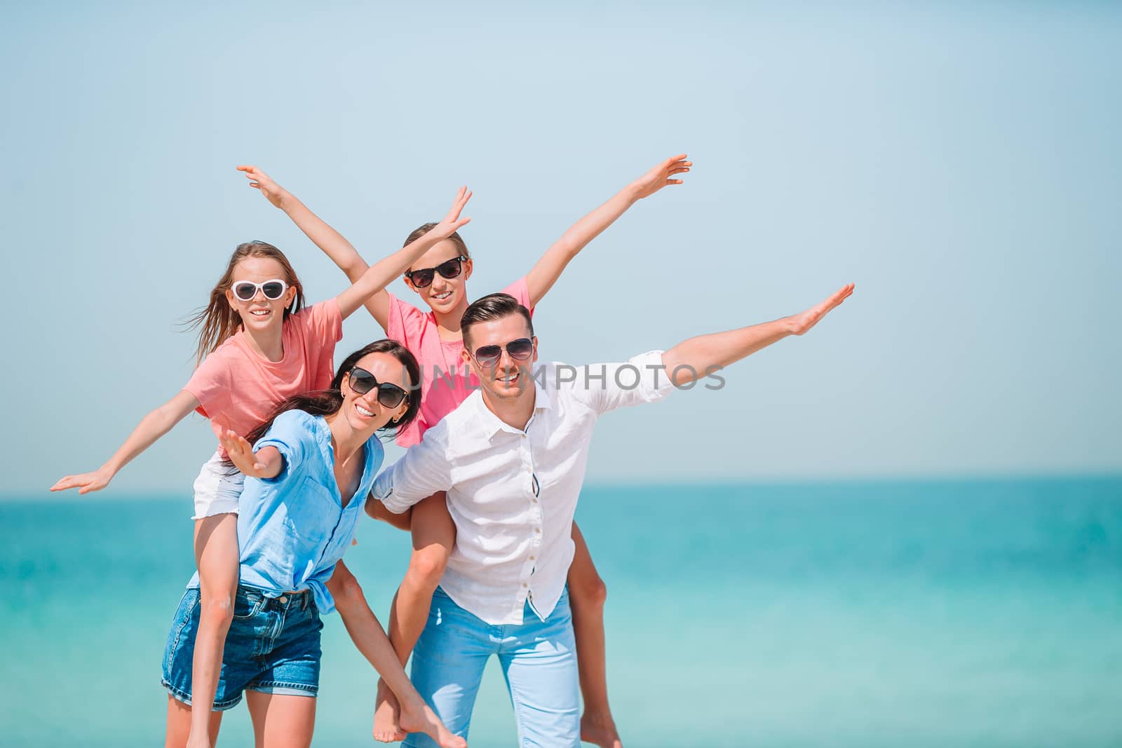 Photo of happy family having fun on the beach. Summer Lifestyle by travnikovstudio
