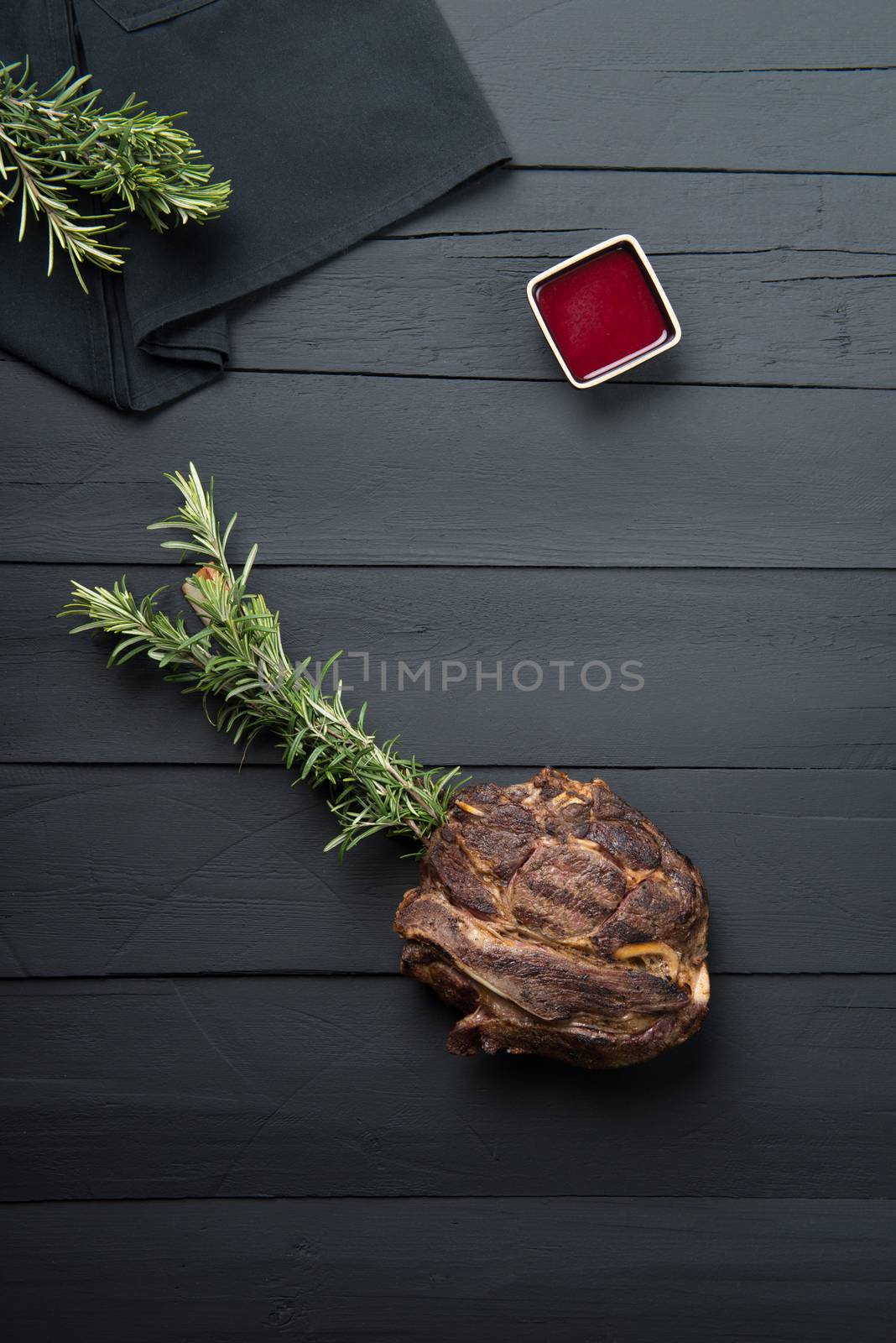 fried meat with greens, sauce and gravy on a black wooden background