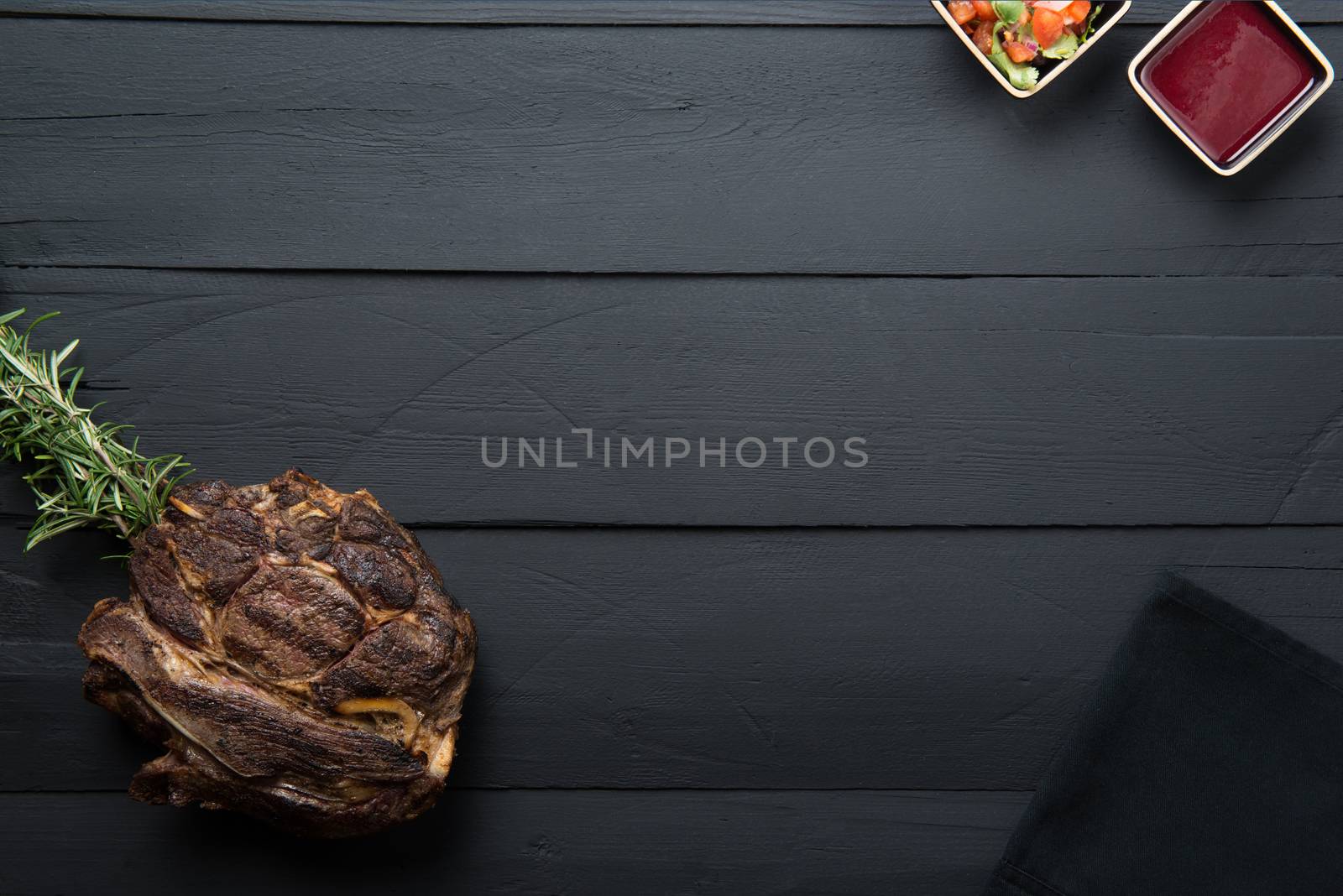 fried meat with greens, sauce and gravy on a black wooden background