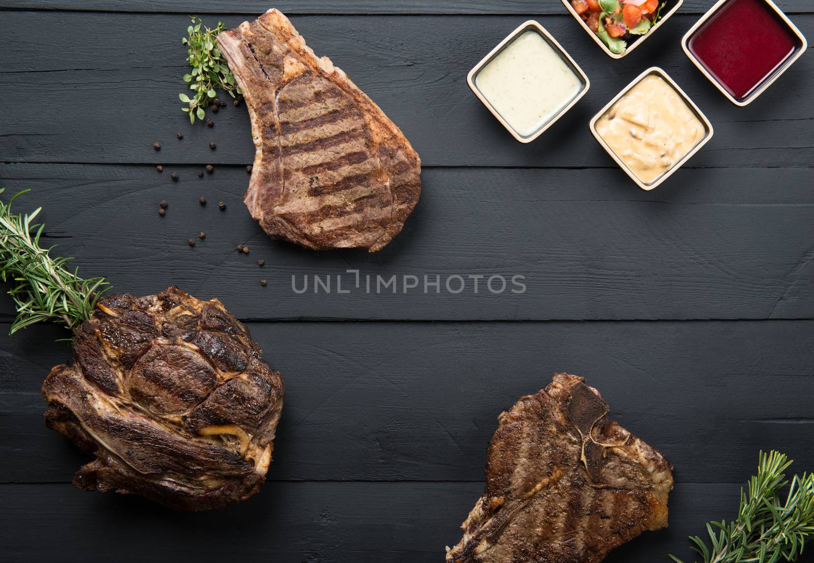 fried meat with greens, sauce and gravy on a black wooden background