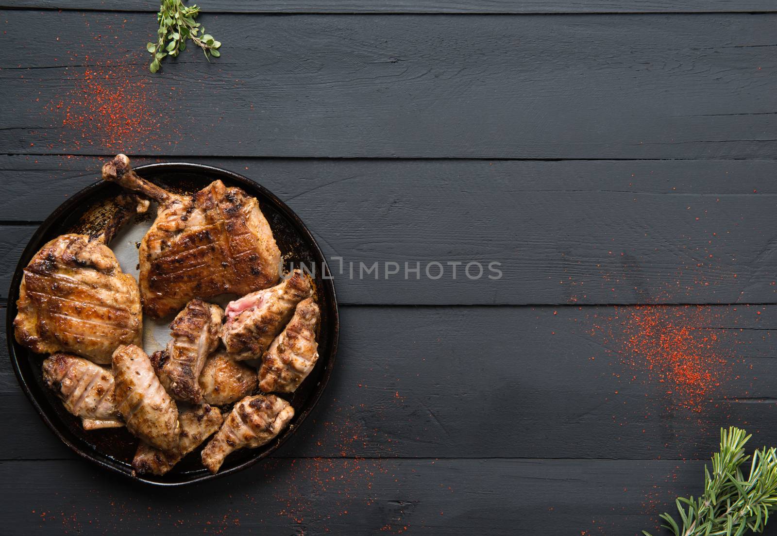 roasted meat in a pan on a black wooden background