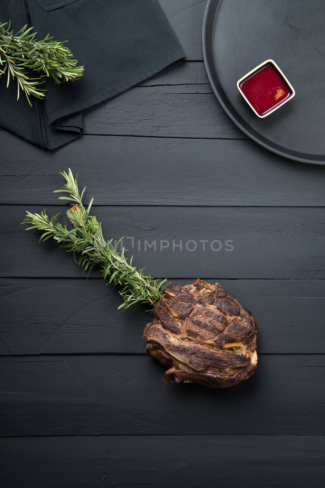 fried meat with greens, sauce and gravy on a black wooden background