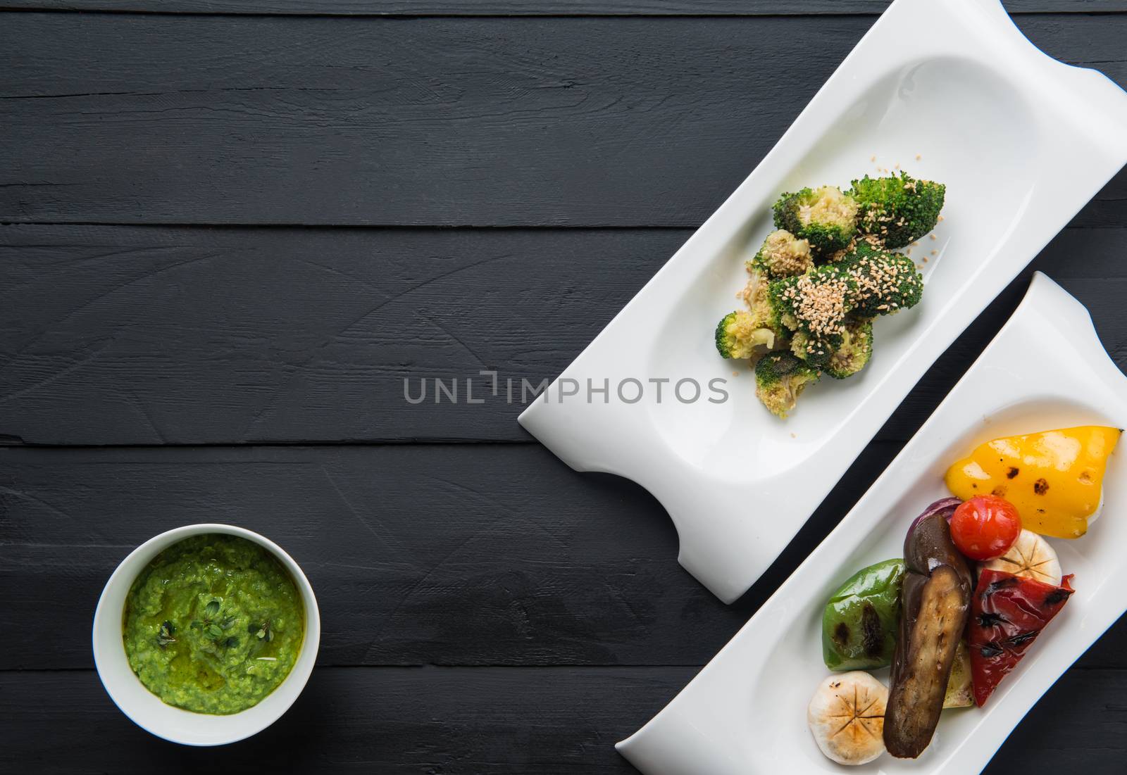 salads and vegetable food in plates on a black wooden background