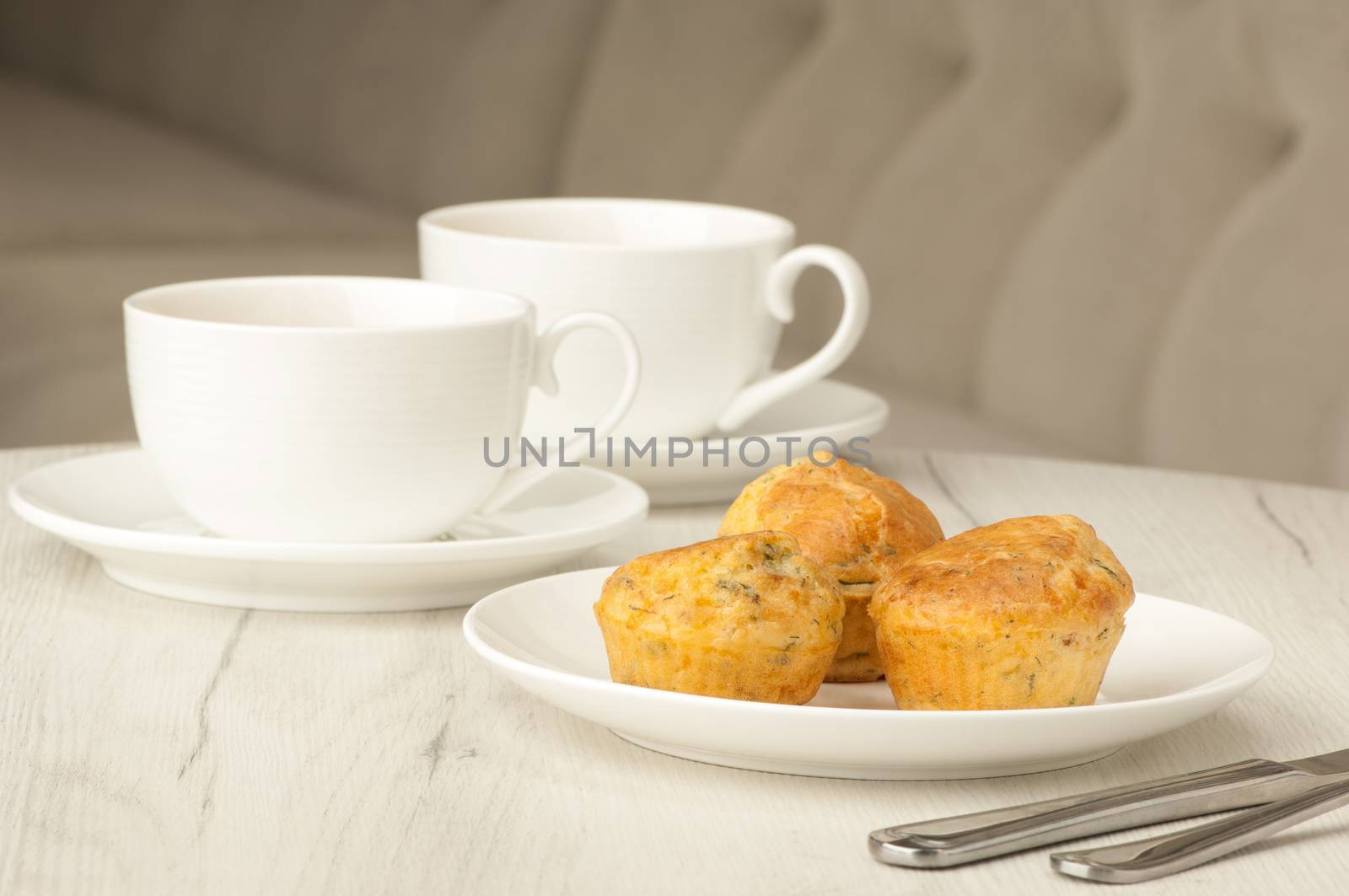 cake and two cups of coffee on a table with cutlery