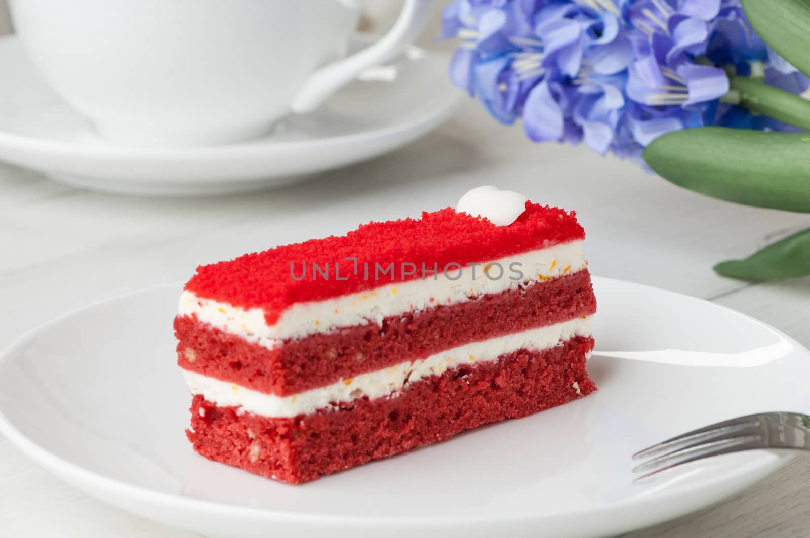 cake with a fork on a saucer and a flower on the table closeup