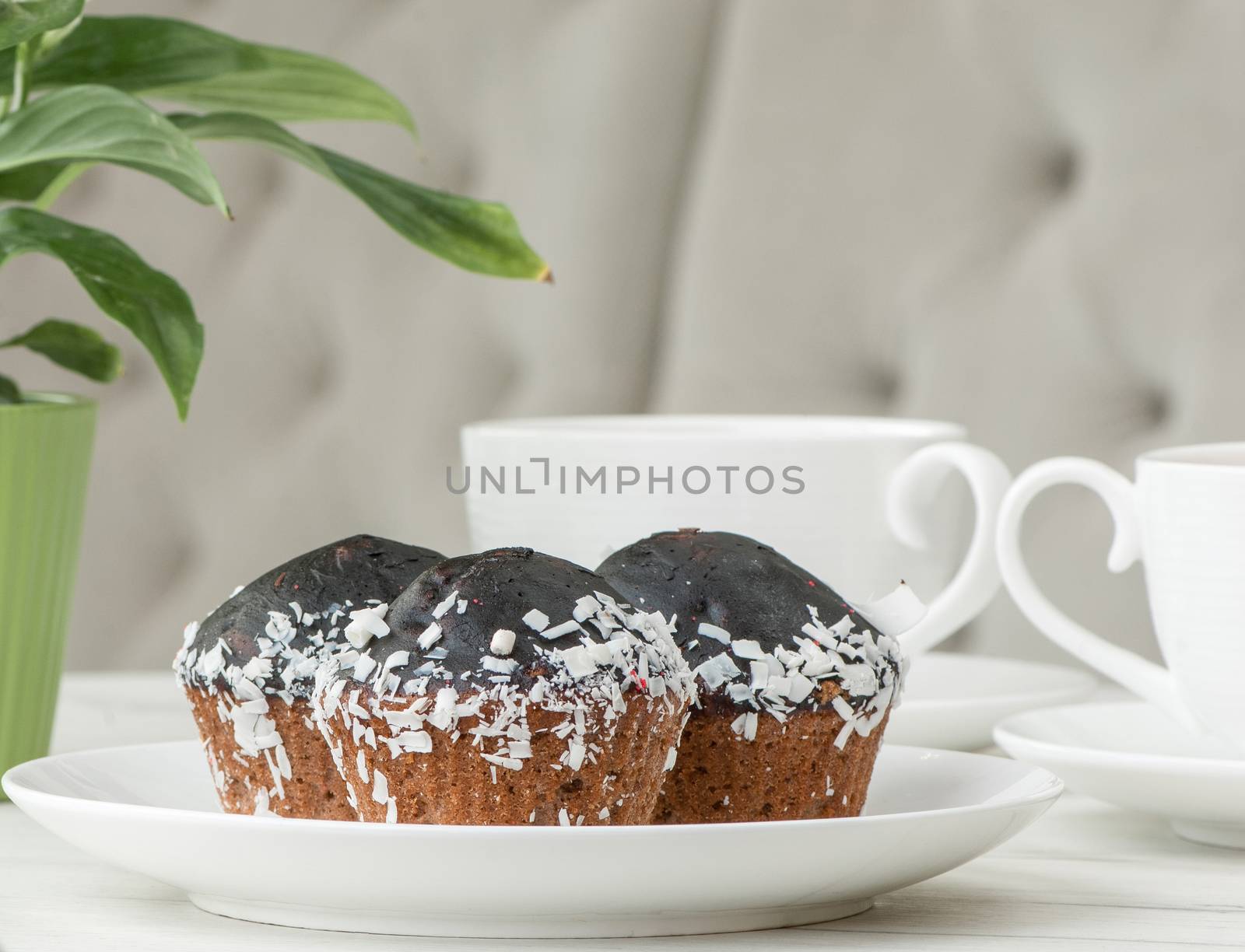 cake on a plate and two cups of tea on the table with flowers