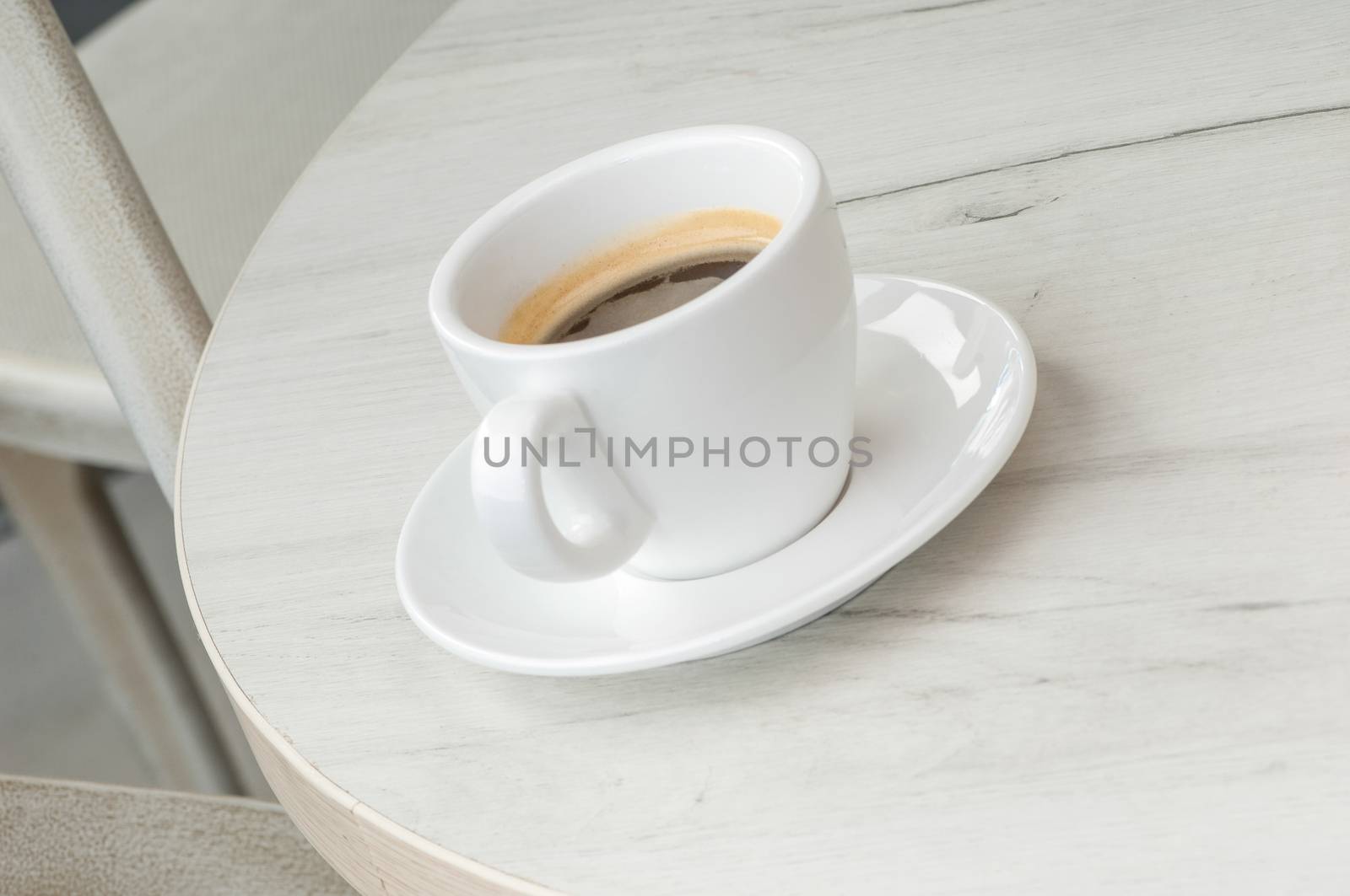 Coffee cup and saucer on a round table