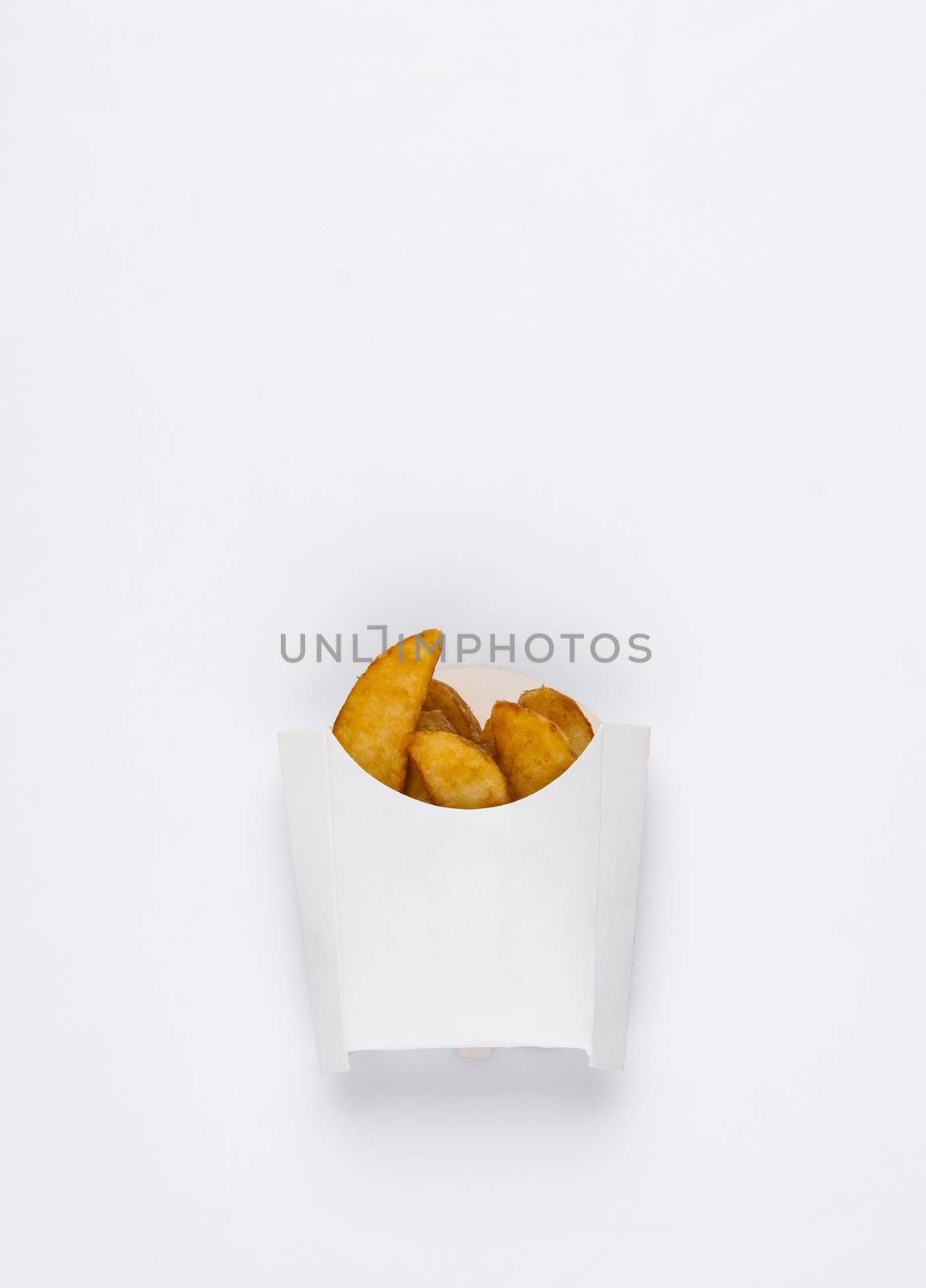 slices of fried potatoes in a white box on a white background. studio photo of fried french fries on white background