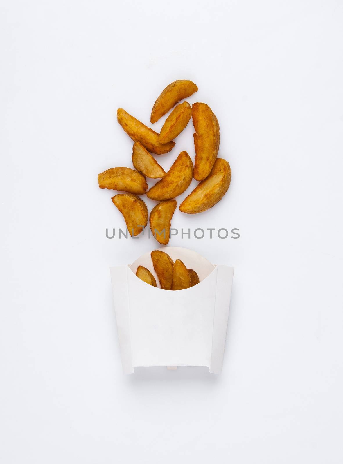 slices of fried potatoes in a white box on a white background. studio photo of fried french fries on white background