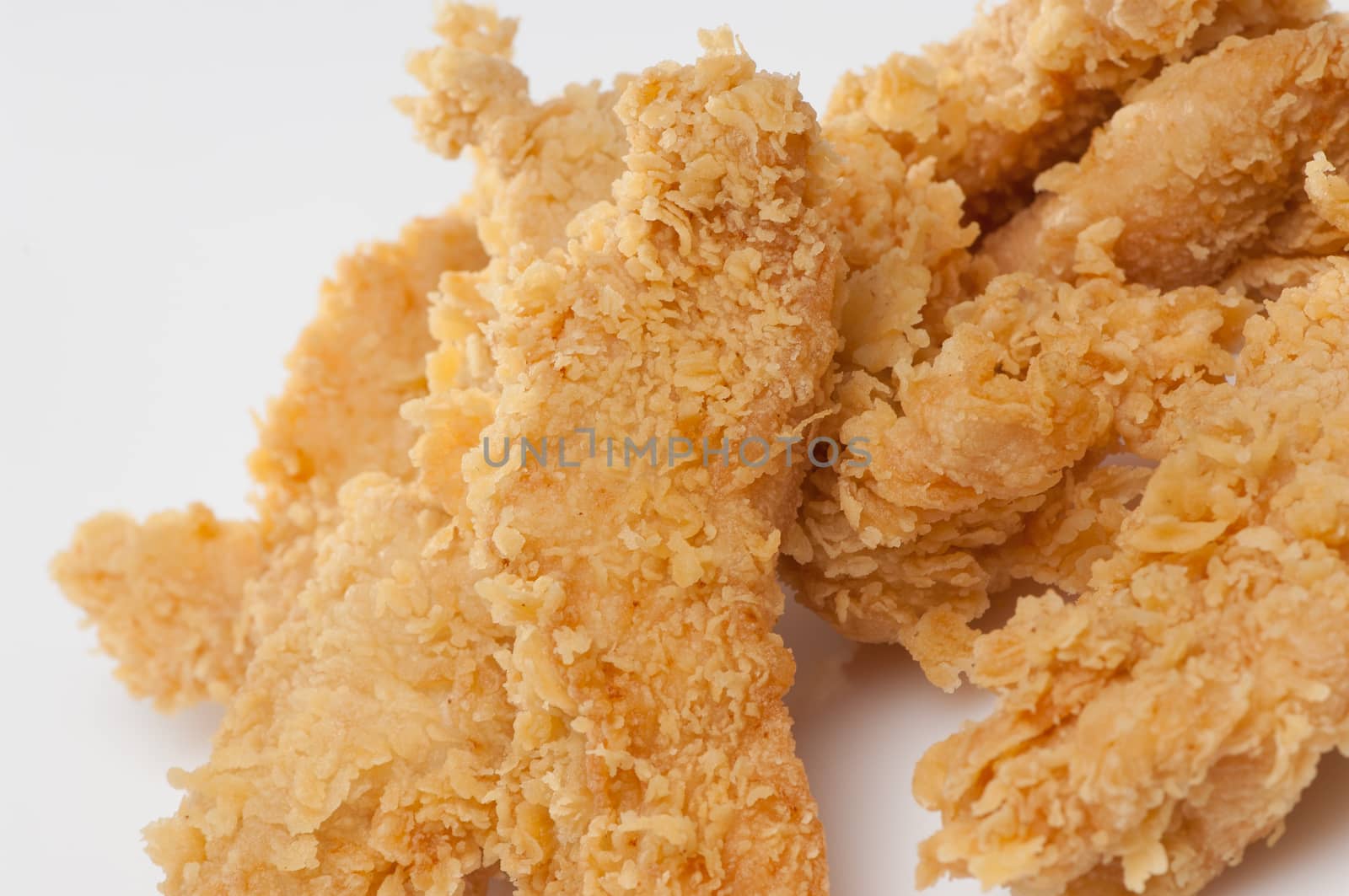 chicken pieces in bread crumbs close up on a white background