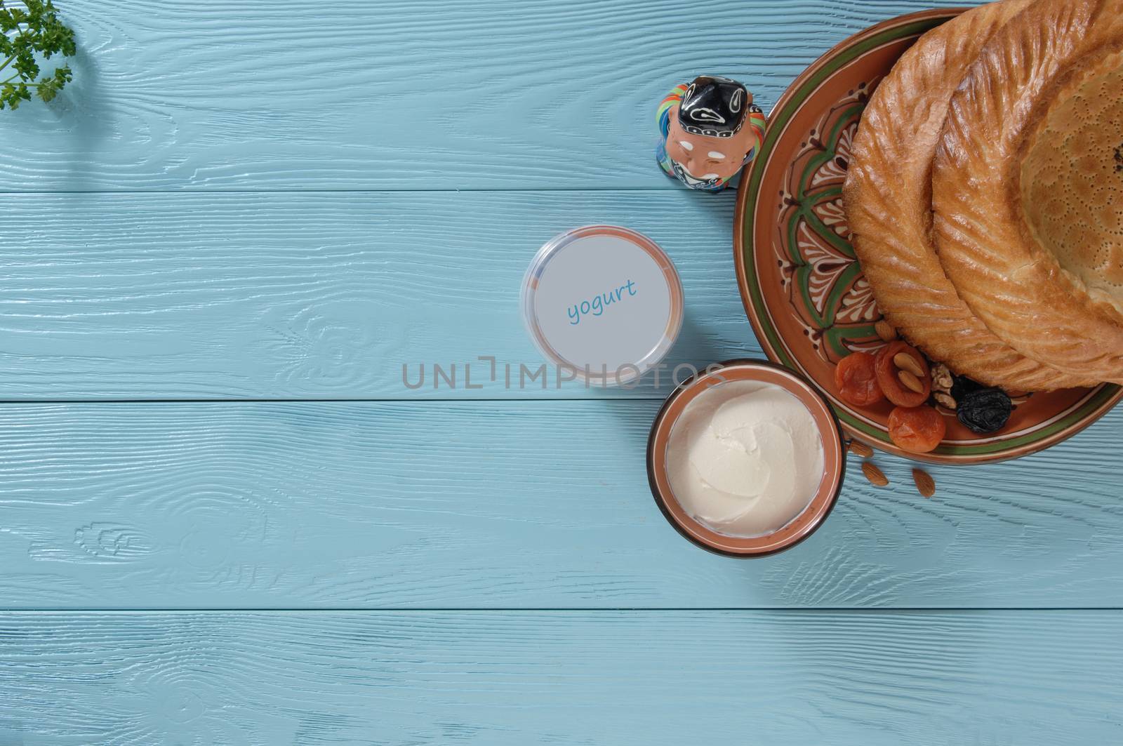 yogurt in a plastic package with a flat cake on a blue wooden background, top view. healthy eating concept