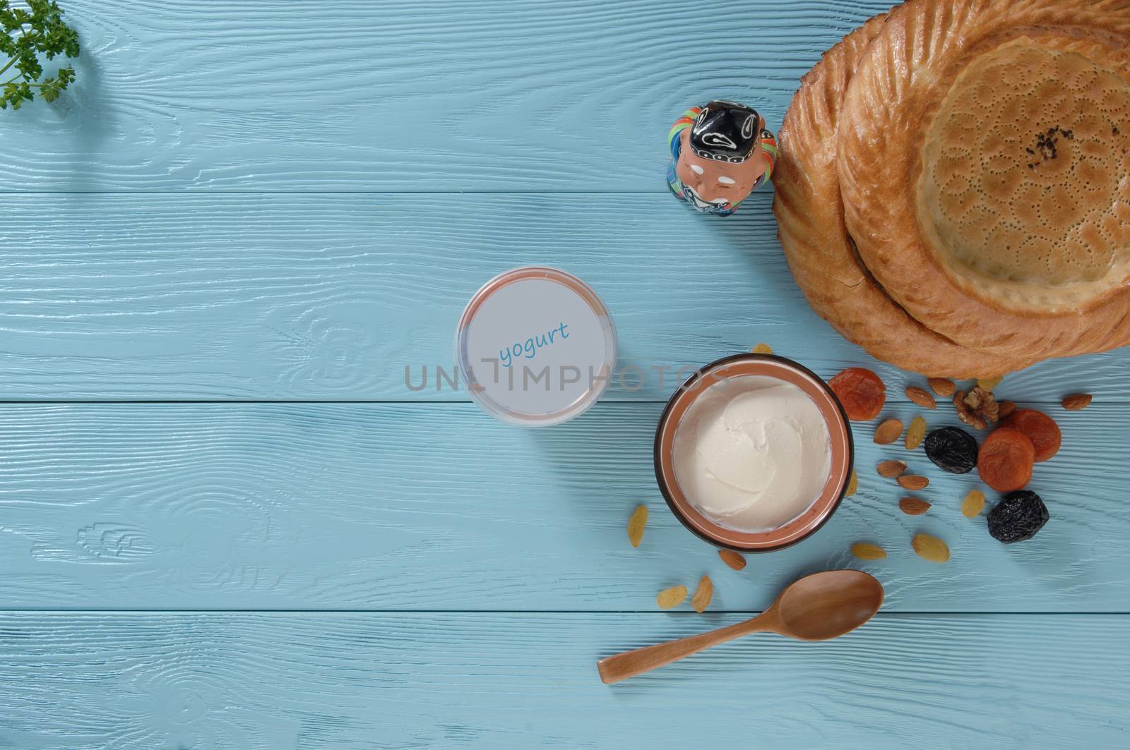 yogurt in a plastic package with a flat cake on a blue wooden background, top view. healthy eating concept