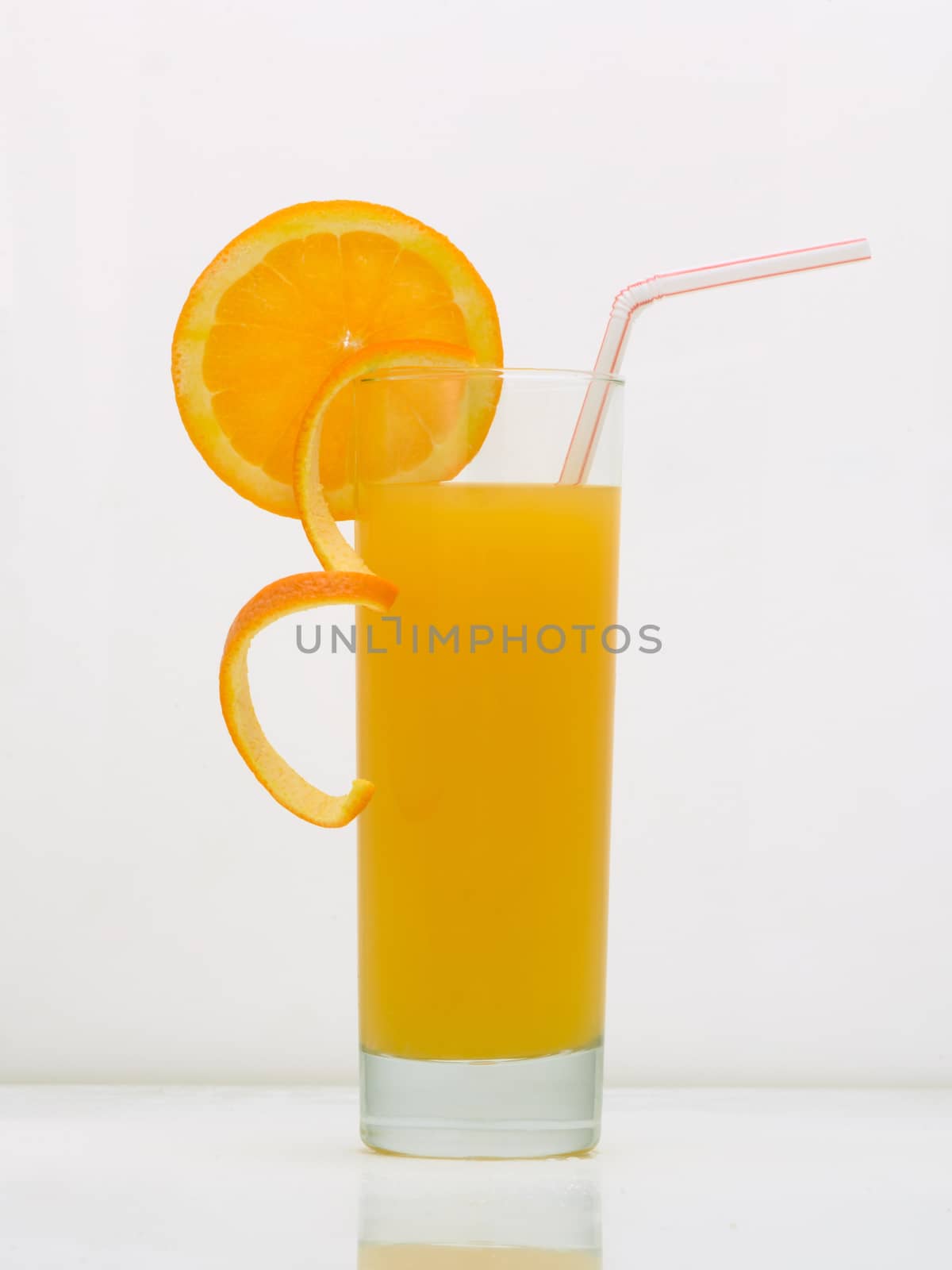 orange drink in a glass with a slice of grapefruit and straw. drink isolated on white background