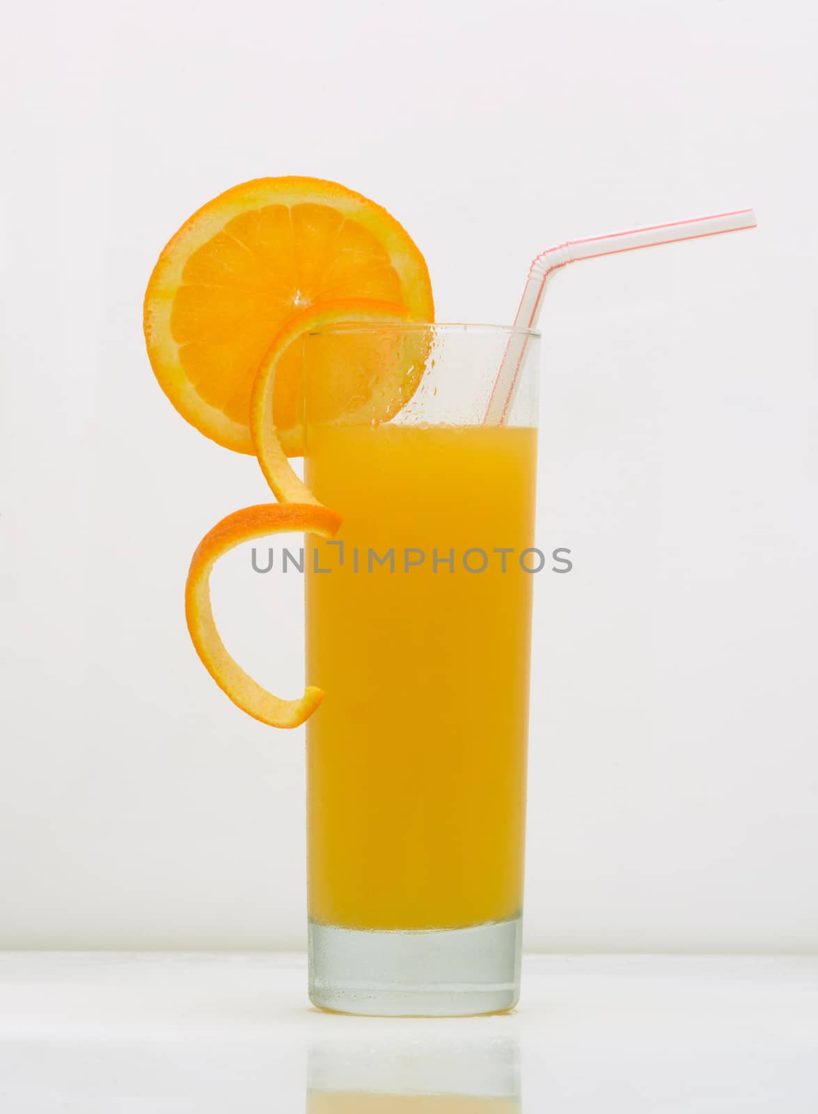 orange drink in a glass with a slice of grapefruit and straw. drink isolated on white background